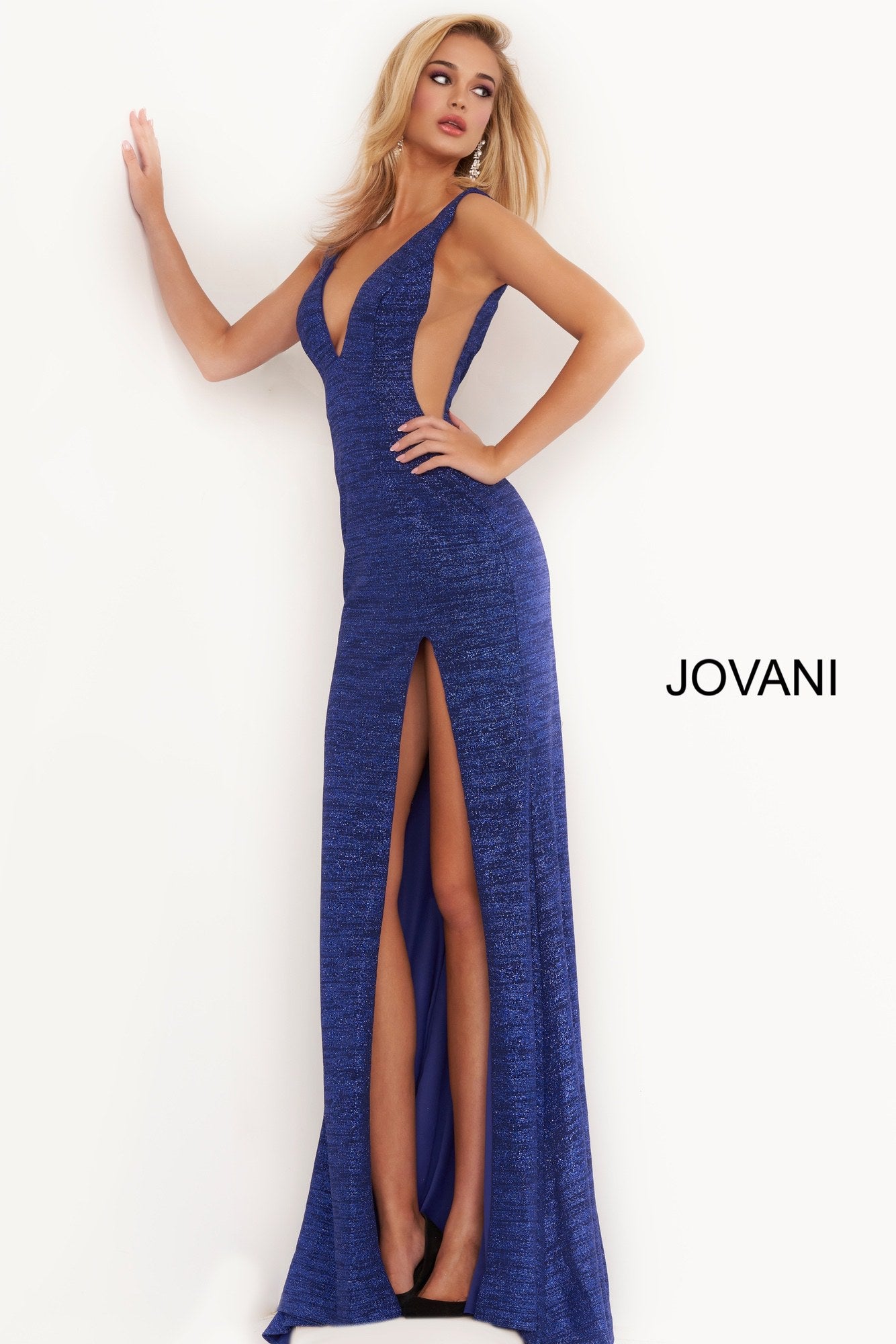 Jovani 02472 is a long Fitted 2020 Prom, Pageant & Formal Evening dress. Featuring a Stretch Glitter jersey material for a touch of shimmer. V Neckline and open v back. sheer side cutout panels. slit in the skirt and small sweeping train. Stretch glitter prom dress, form fitting silhouette, floor length skirt with high slit and train, sleeveless bodice, sheer side inserts, V neck, open back. Available Colors: black/gold, black/multi, gunmetal, hot-pink, jade, red, royal, soft blue/silver