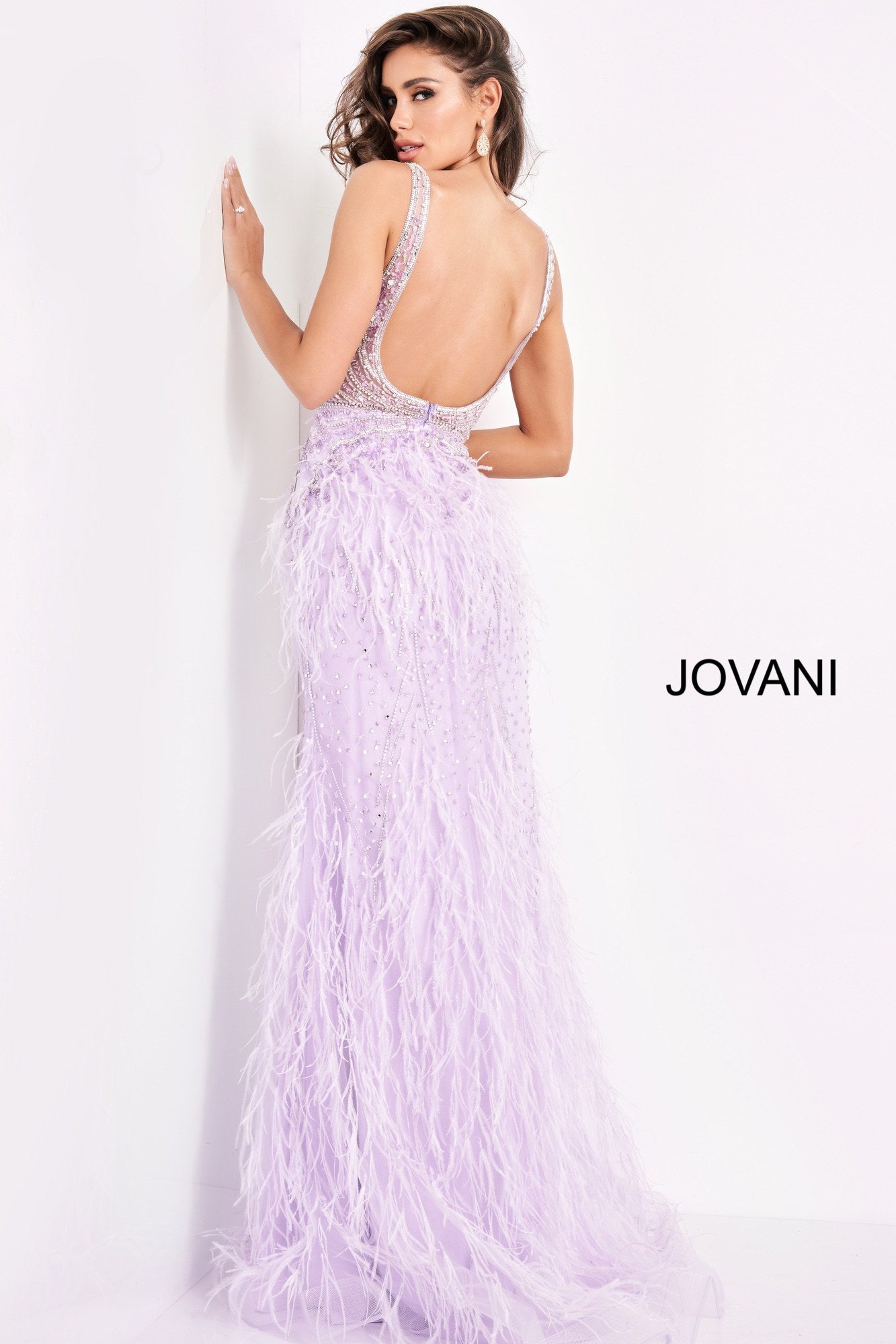 Jovani 03023 is a 2021 Prom Dress, Pageant Gown, Wedding Dress & Formal Evening wear. This Sheer embellished bodice features a plunging v neckline with beading & crystal accents cascading through a feather embellished skirt. Very stunning and unique wedding dress!   Available Colors: Off White, Blush, Black  Available Sizes: 00-24