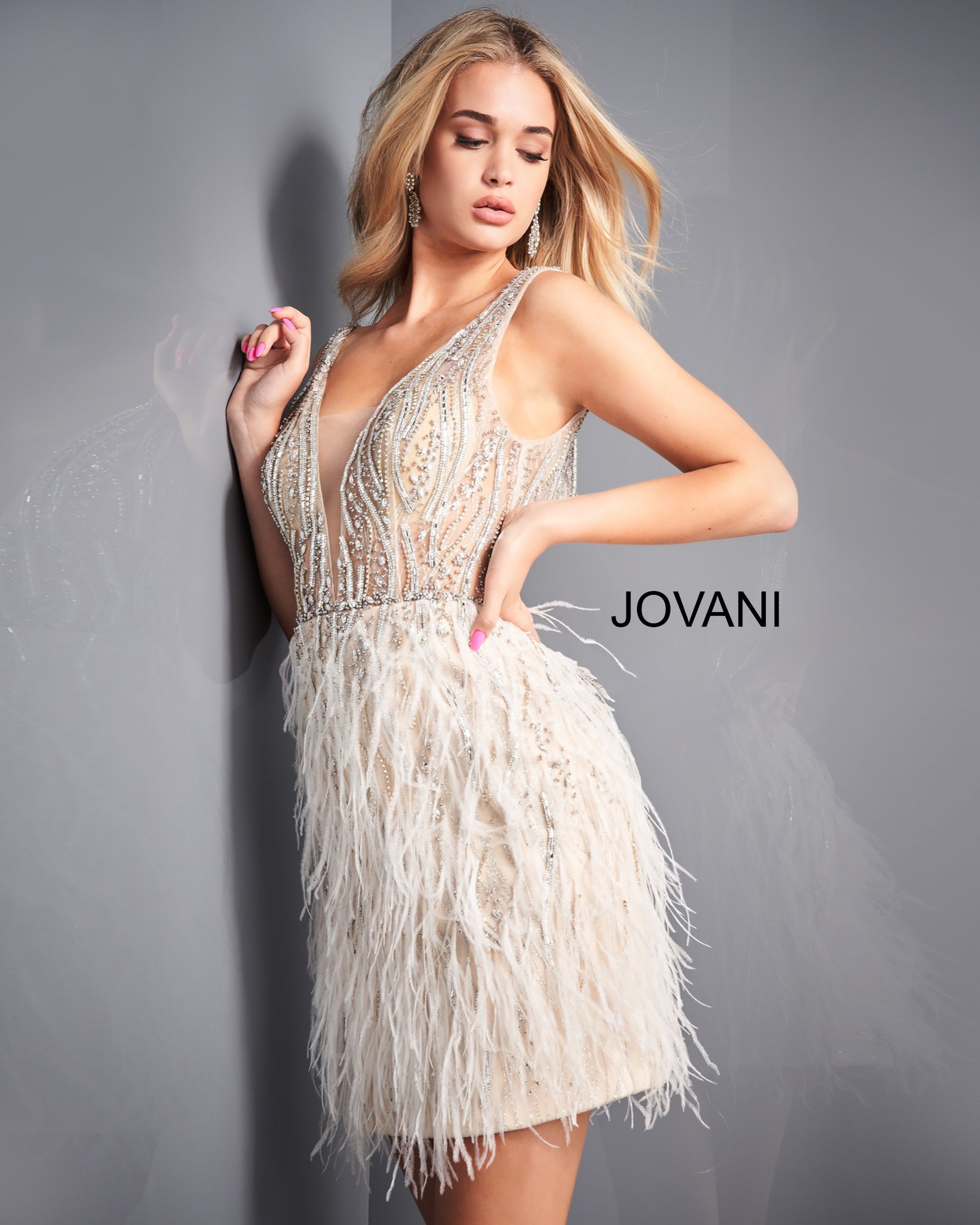Jovani 04619 is a short feather embellished formal cocktail dress. Sheer Beaded & Embellished Fitted Bodice with a deep V Plunging neckline and sheer mesh insert. open v back. Embellishments cascade down into the sheath short skirt surrounded by lush feather accents. This dress is perfect for Prom, Pageant, Red Carpet, Homecoming & So many more formal events.