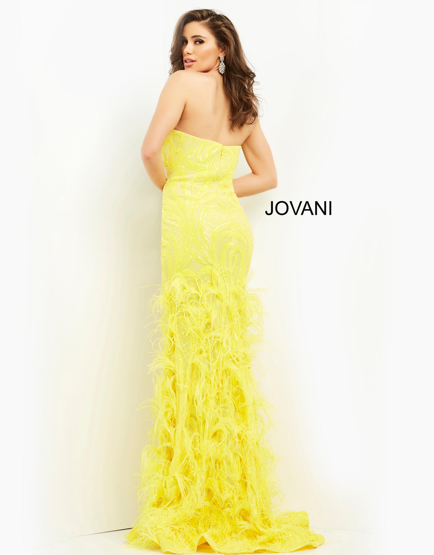 Jovani 05667 This is a long prom dress with feather details on the bottom of the skirt.  This pageant gown has a sweetheart neckline and is strapless.  Perfect evening gown for a Red Carpet event.  Colors:  Yellow, White  Sizes  00-24