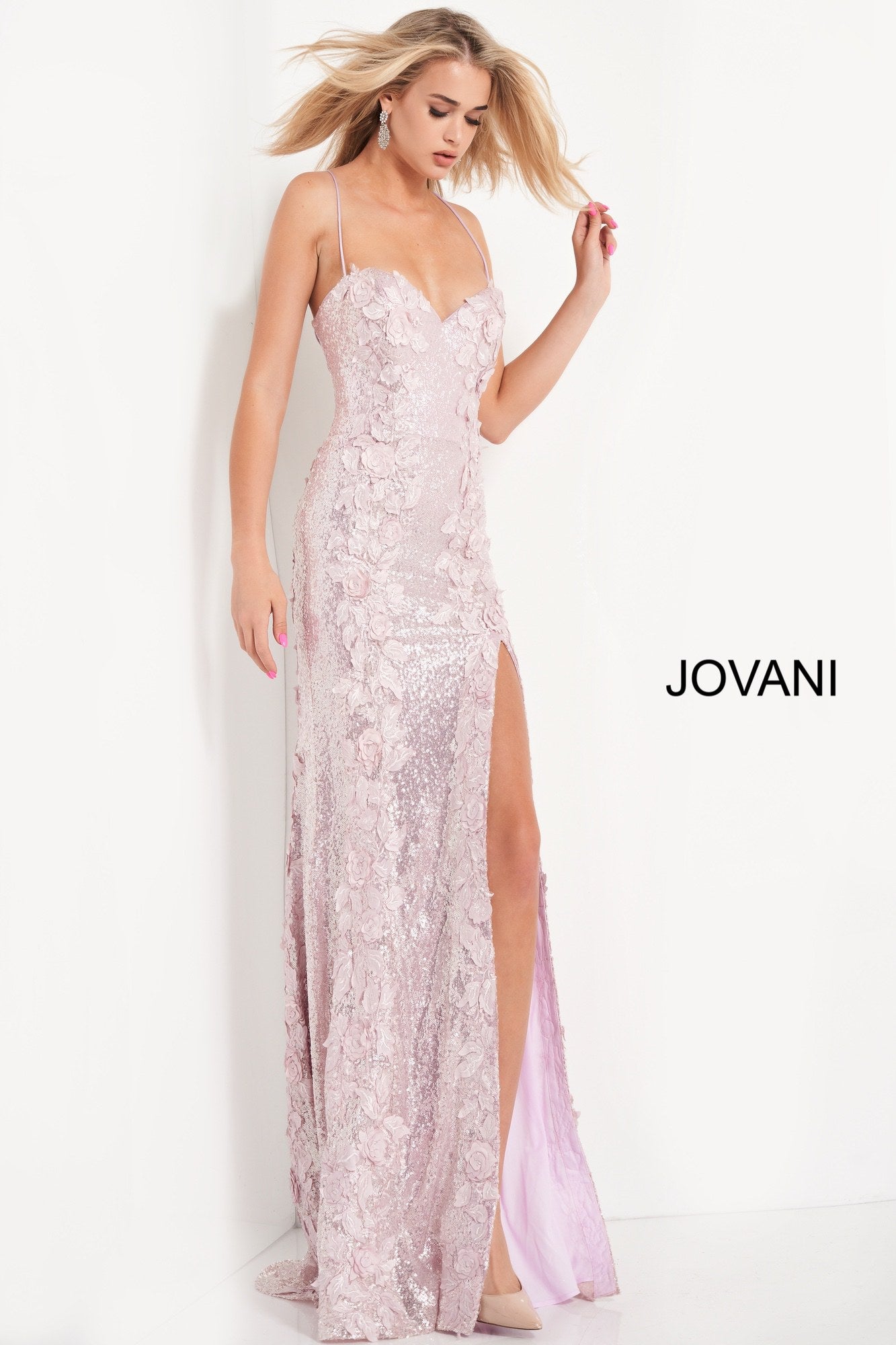 Jovani 06109 is a Long Fitted Sequin Embellished Formal Evening Gown. This Sweetheart neckline prom dress has spaghetti straps that lead around to an open back with a lace up corset tie closure. Detailed 3D Floral Appliques Embellished the fitted bodice & Cascade down the length of this gorgeous Pageant Gown. Thigh Slit in Skirt. Embellishments also adorn the back length of the Gown trailing into a Lush sequin sweeping train.