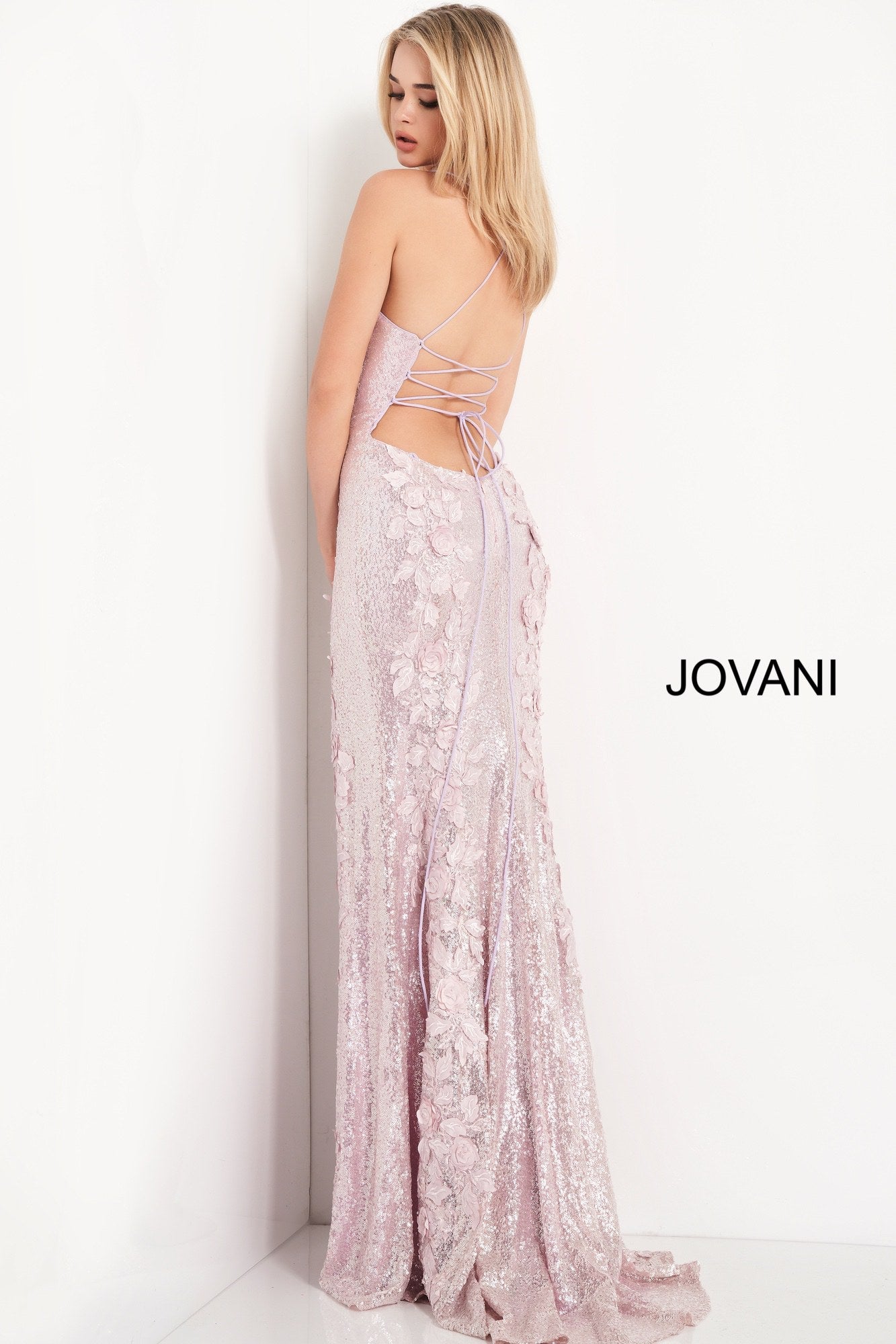 Jovani 06109 is a Long Fitted Sequin Embellished Formal Evening Gown. This Sweetheart neckline prom dress has spaghetti straps that lead around to an open back with a lace up corset tie closure. Detailed 3D Floral Appliques Embellished the fitted bodice & Cascade down the length of this gorgeous Pageant Gown. Thigh Slit in Skirt. Embellishments also adorn the back length of the Gown trailing into a Lush sequin sweeping train.