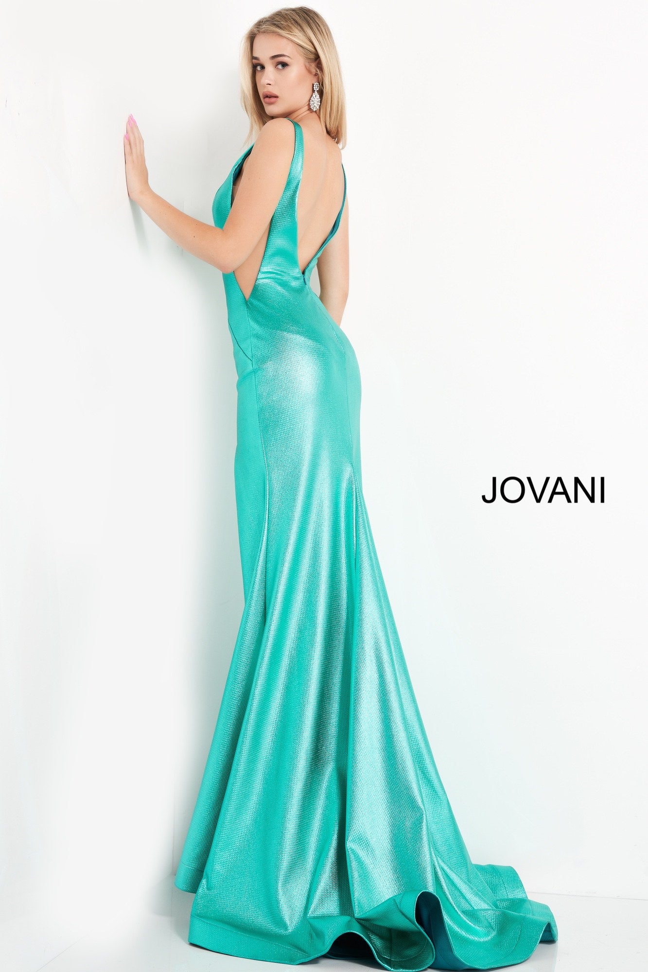 Jovani 06125 is a gorgeous Long Fitted metallic shimmer Formal Evening Gown. Plunging Deep V Neckline with an open V Back. Fit & Flare silhouette with s slit in the thigh and a lush trumpet skirt with Gorgeous sweeping train. Sheer side panels with mesh insert.
