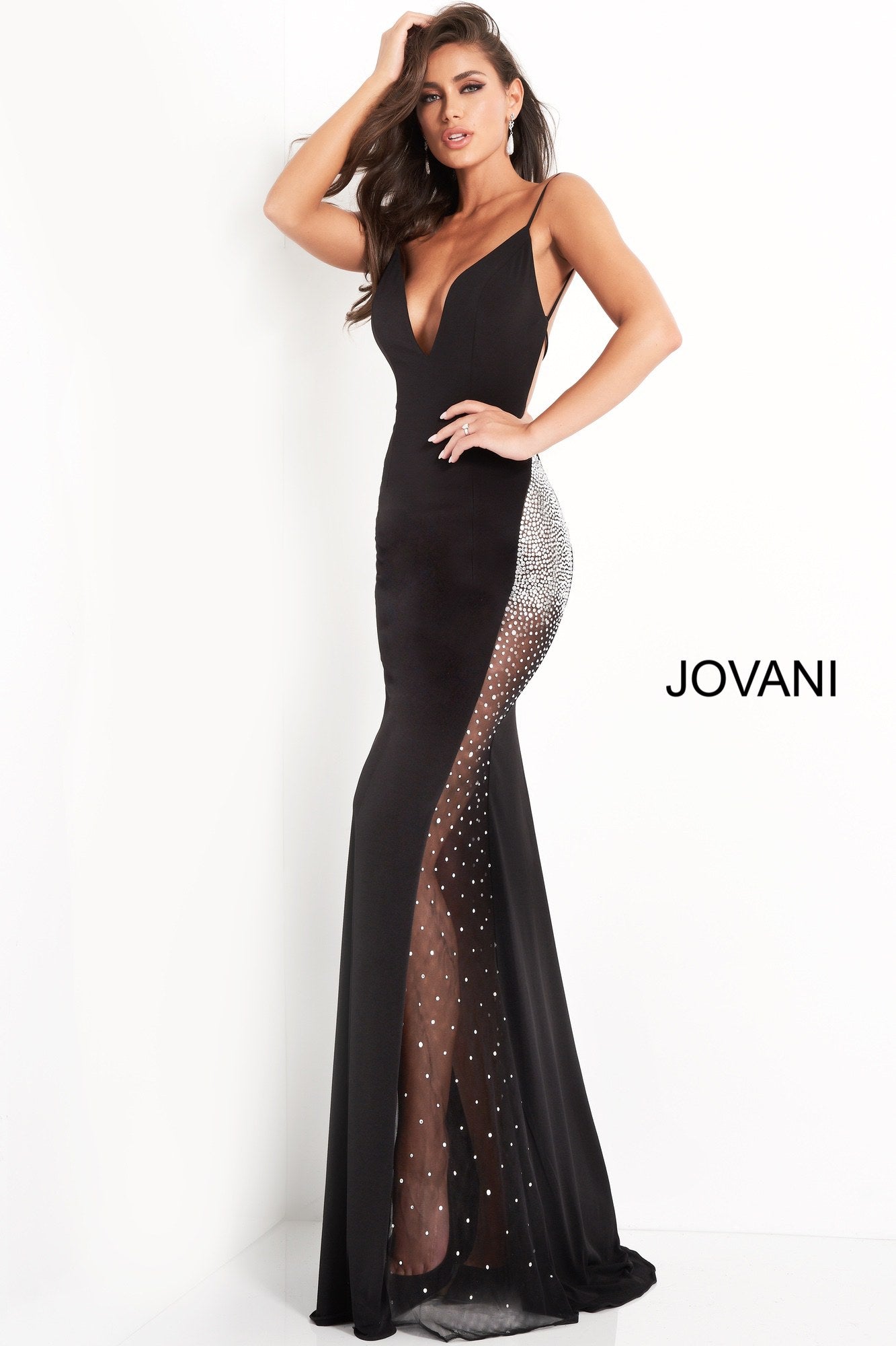 Jovani 06566 is a long fitted formal evening gown. Featuring a deep V Neckline with spaghetti straps and an open back. Sheer side panel on skirt has crystal rhinestones along the hip area dispersing as it flows down the skirt. Great Red Carpet Sexy Black Dress. Available Sizes: 00,0,2,4,6,8,10,12,14,16,18,20,22,24  Available Colors: Black, Light Blue, Red