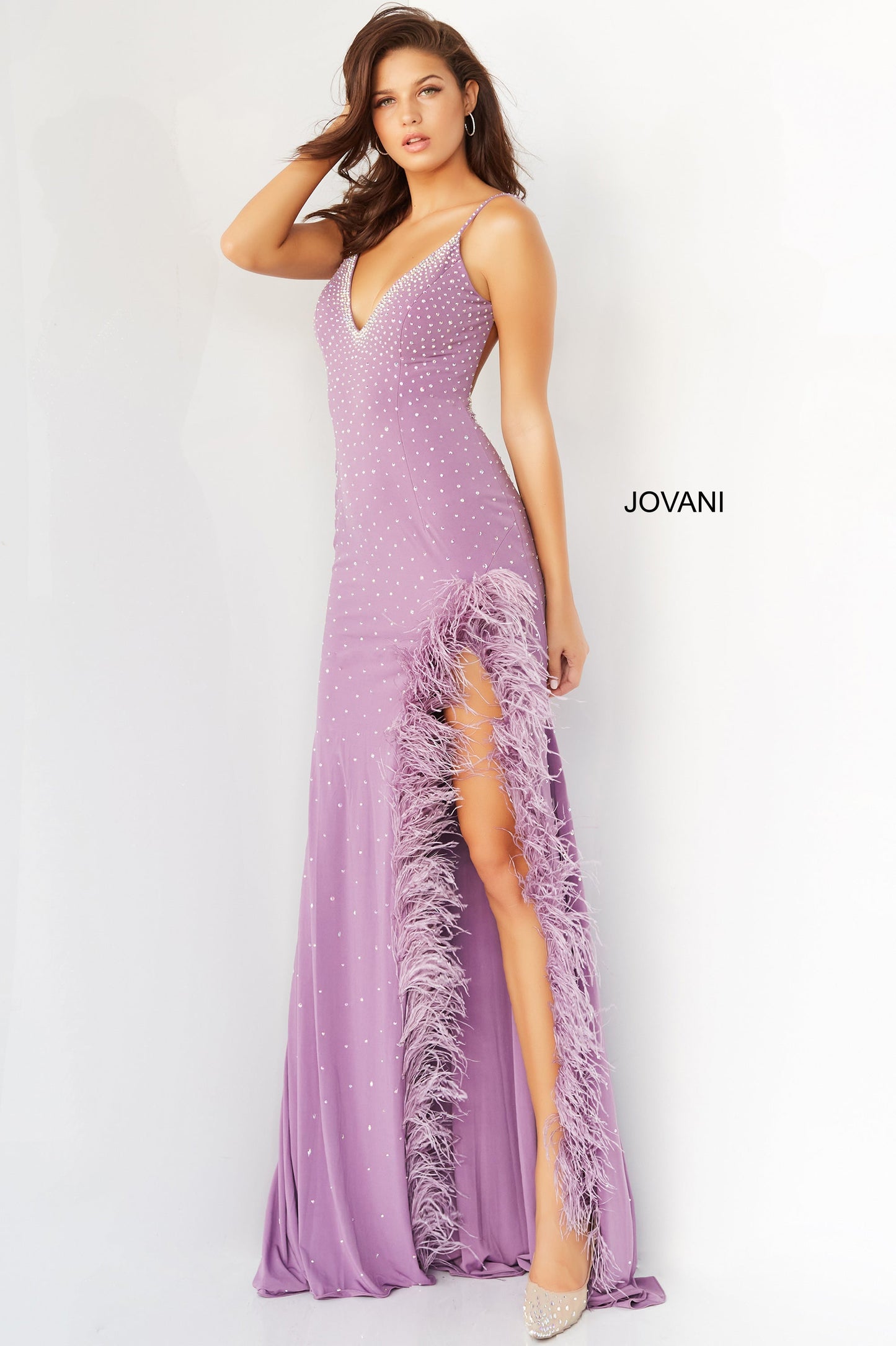 Jovani 08283  Prom, Pageant and Formal Evening Wear Dress.  This extravagant evening gown has a v neckline and low back.  It is fitted and beaded with a feather trimmed slit. Make a statement in this stand out prom dress. Lilac front