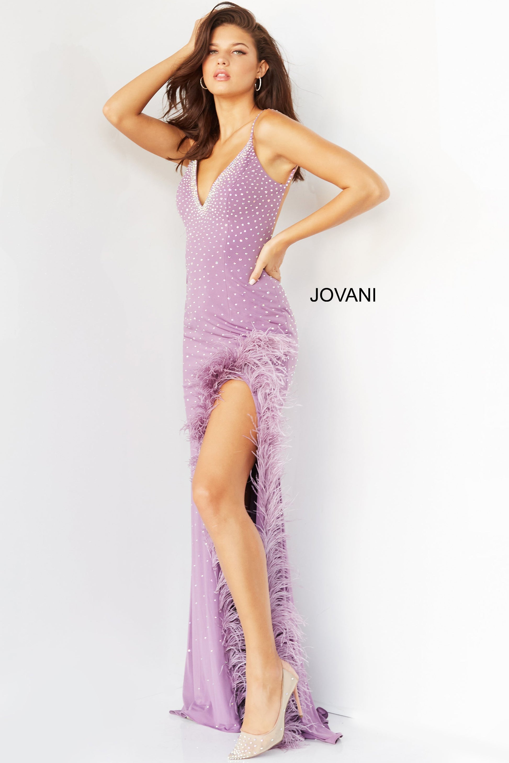 Jovani 08283  Prom, Pageant and Formal Evening Wear Dress.  This extravagant evening gown has a v neckline and low back.  It is fitted and beaded with a feather trimmed slit. Make a statement in this stand out prom dress.