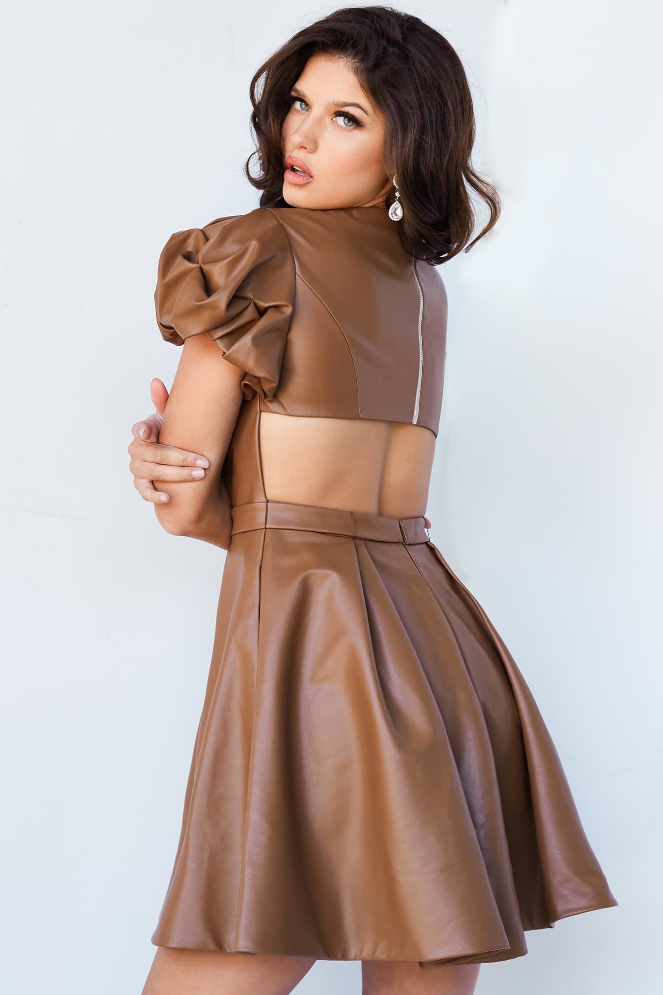 Jovani 09690 Short Fit & Flare Pleather Cutout Back Puff Sleeve Formal Cocktail Dress Interview This Jovani 09690 caramel cocktail dress features an A-line silhouette in premium pleather, with a square neckline, puff sleeves, and a lower back cutout.  Available Sizes: 00,0,2,4,6,8,10,12,14,16,18,20,22,24  Available Colors: Black, Caramel, Olive
