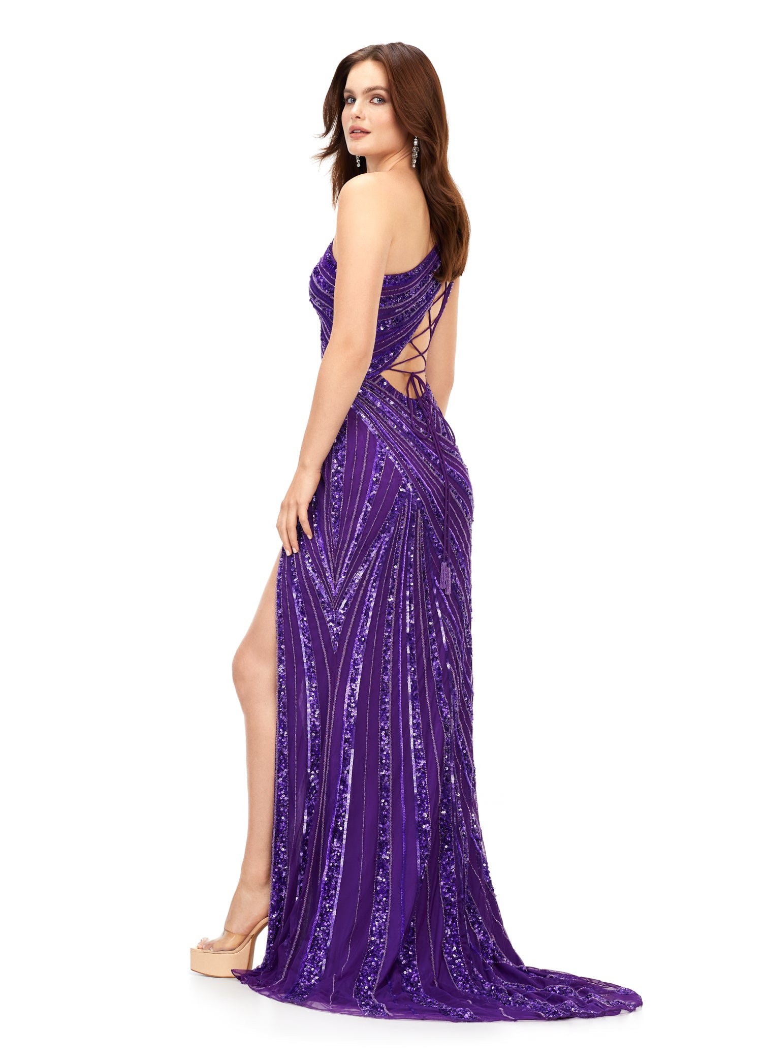 Ashley Lauren 11244 Long Sequin One Shoulder Prom Dress Formal Slit Gown Corset  This one shoulder gown features an intricate bead pattern that will accentuate your curves. The look is complete with a left leg slit and our signature asymmetrical lace up back. One Shoulder Lace Up Back Left Leg Slit Fully Hand Beaded Sizes: 00-18 Colors:  Purple, Neon Blue, AB/Ivory, Royal/Turquoise, Electric Coral, Jade, Neon Pink, Orchid