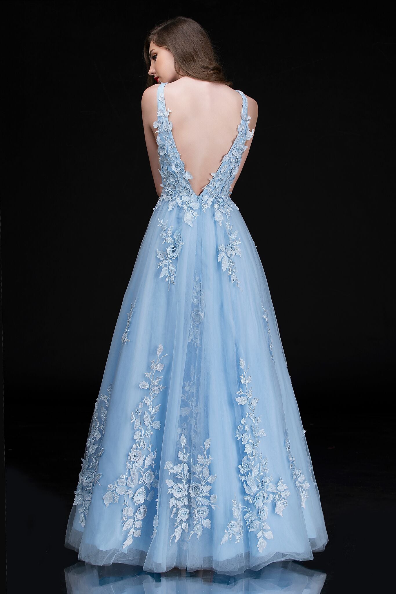 Nina Canacci 1495 is a long 3d Floral Applique embellished Deep V Neck Prom Dress. This Romantic formal gown features embellished floral appliques cascading into the tulle A Line Ballgown Skirt. Great Formal dress.  Available Sizes: 0-10  Available Colors: Ice Blue, Ivory