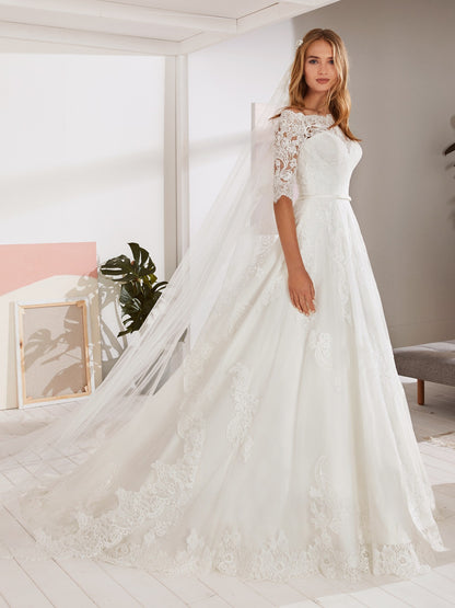 White One OSSA by Pronovias is Probably the wedding dress most little girls have dreamed of; this classic lace tulle gown has the sweetest of necklines with a lace yoke, pretty, lacey school-girl sleeves and a full-blown skirt with a scalloped edge. A Line Lace Ballgown with off the shoulder eyelash three quarter length sheer sleeves. Embroidered Lace Stunning Plus Size Bridal Gown!  Available Size: 28  Available Color: Off White