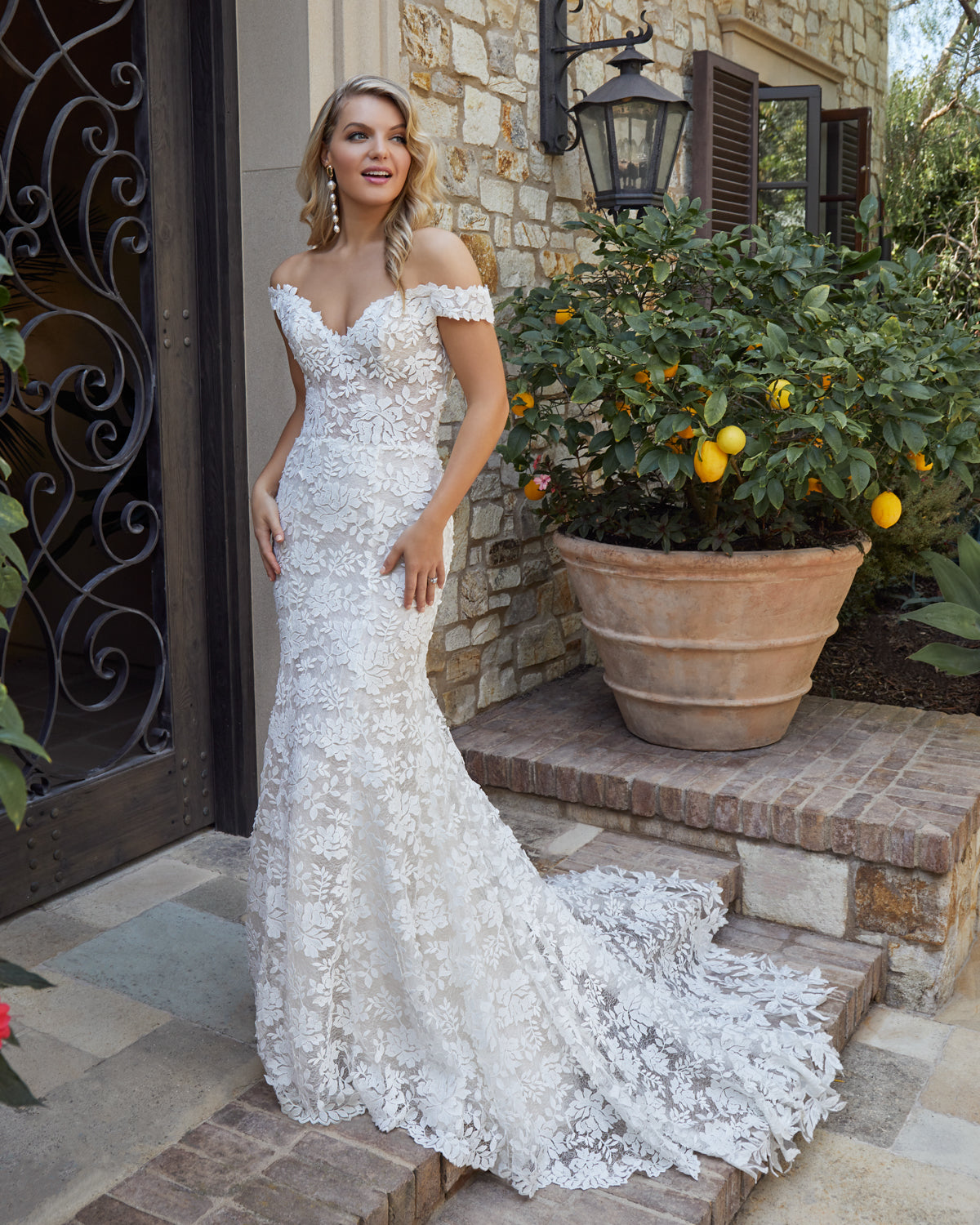 Casablanca Bridal 2446 Evelyn  Modern lace meets a classic silhouette to create enchanting Style 2446. This fit and flare wedding dress features the most charming, bold overlace that sits atop Chantilly lace, silky chiffon and organza for an extra layered element of dimensional detail. Off-shoulder sleeves will give you a fanciful, flirtatious look, while a 56 to 81 inch scalloped edge train makes for that perfect back photo.  Fabric: Chantilly Lace, Organza, Silky Chiffon & Overlace