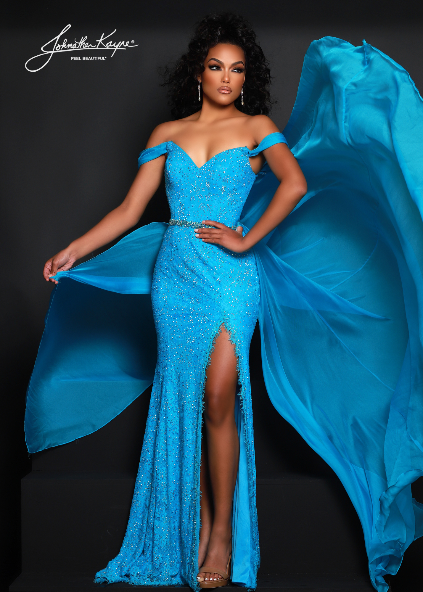 Johnathan Kayne 2715 Long Fitted Lace Pageant Dress Overskirt Slit Prom Gown off the Shoulder Dress up and show up in this chic stretch lace off-the-shoulder gown. The beaded belt that highlights your waist features an overskirt to give you that extra touch.  Colors: Black-Nude, Coral, Royal, Turquoise, White  Sizes: 00, 0, 2, 4, 6, 8, 10, 12, 14, 16, 18, 20  Fabric Stretch Lace, Stretch Lining, Chiffon