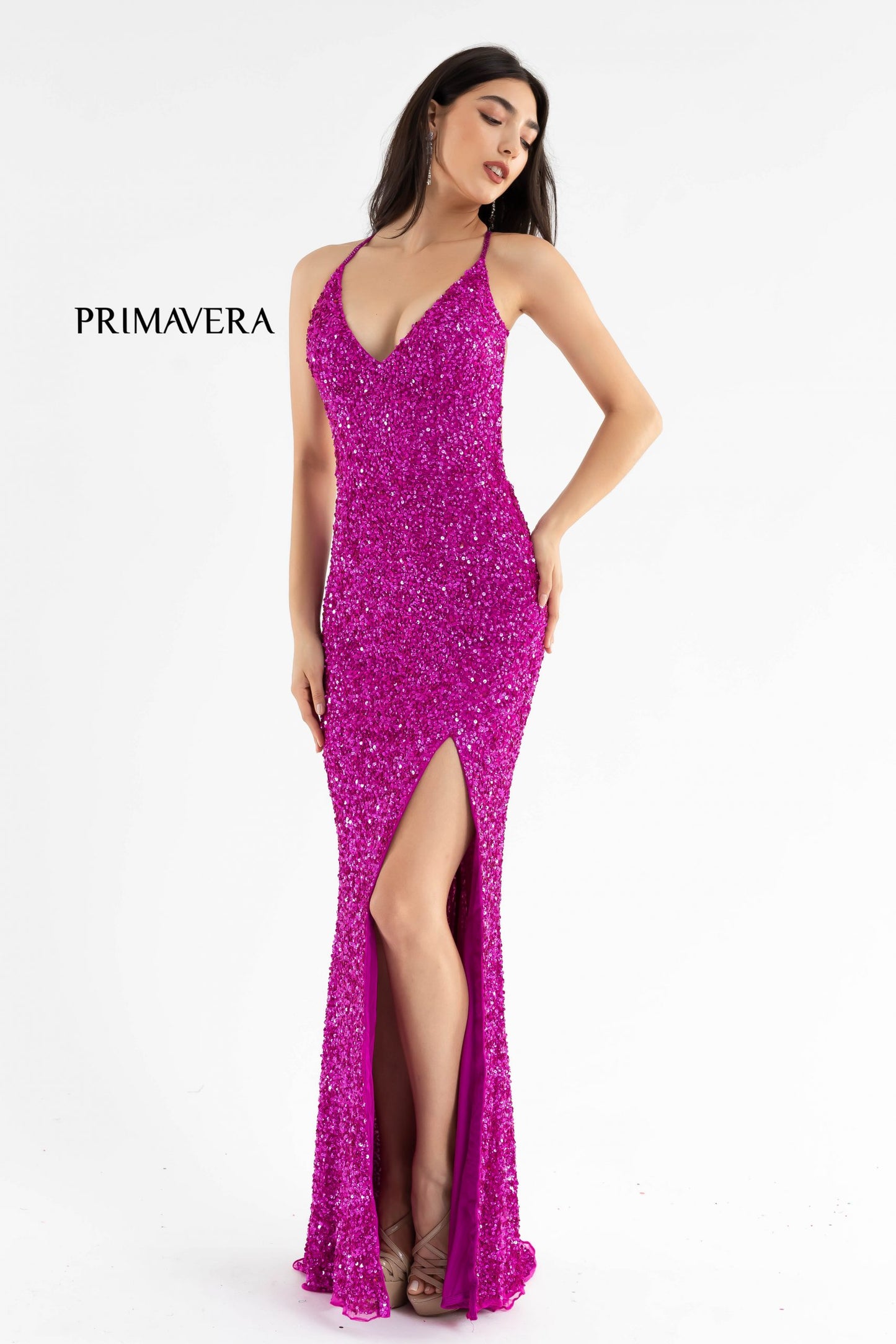 Primavera Couture 3291 Exclusive Prom Dresses.  This long prom dress is embellished throughout with shimmering sequins.  This impressive gown showcases a v neckline, thin beaded straps and crisscrossed straps in the open back. The long slim skirt has a sultry high side front slit. 