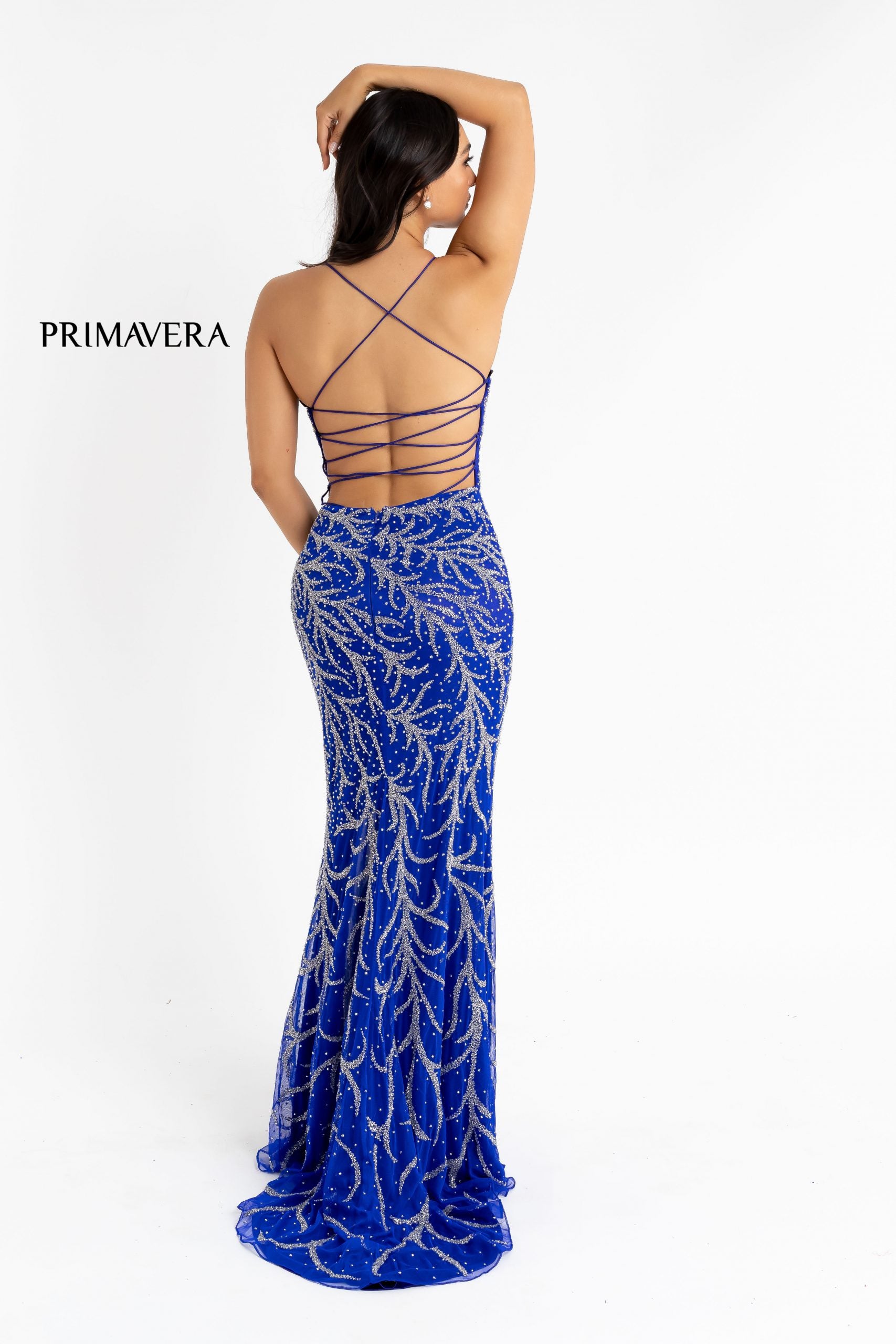 Primavera couture 3636 is a long fitted formal evening gown. This Prom Dress Features a deep V Plunging neckline with mesh insert and spaghetti straps leading around to an open back with a corset lace up tie closure. This Backless Pageant gown Features Beaded Embellishments cascading down the length of the dress. The skirt has a slit & Sweeping train.  Available Sizes: 4  Available Colors: Blue