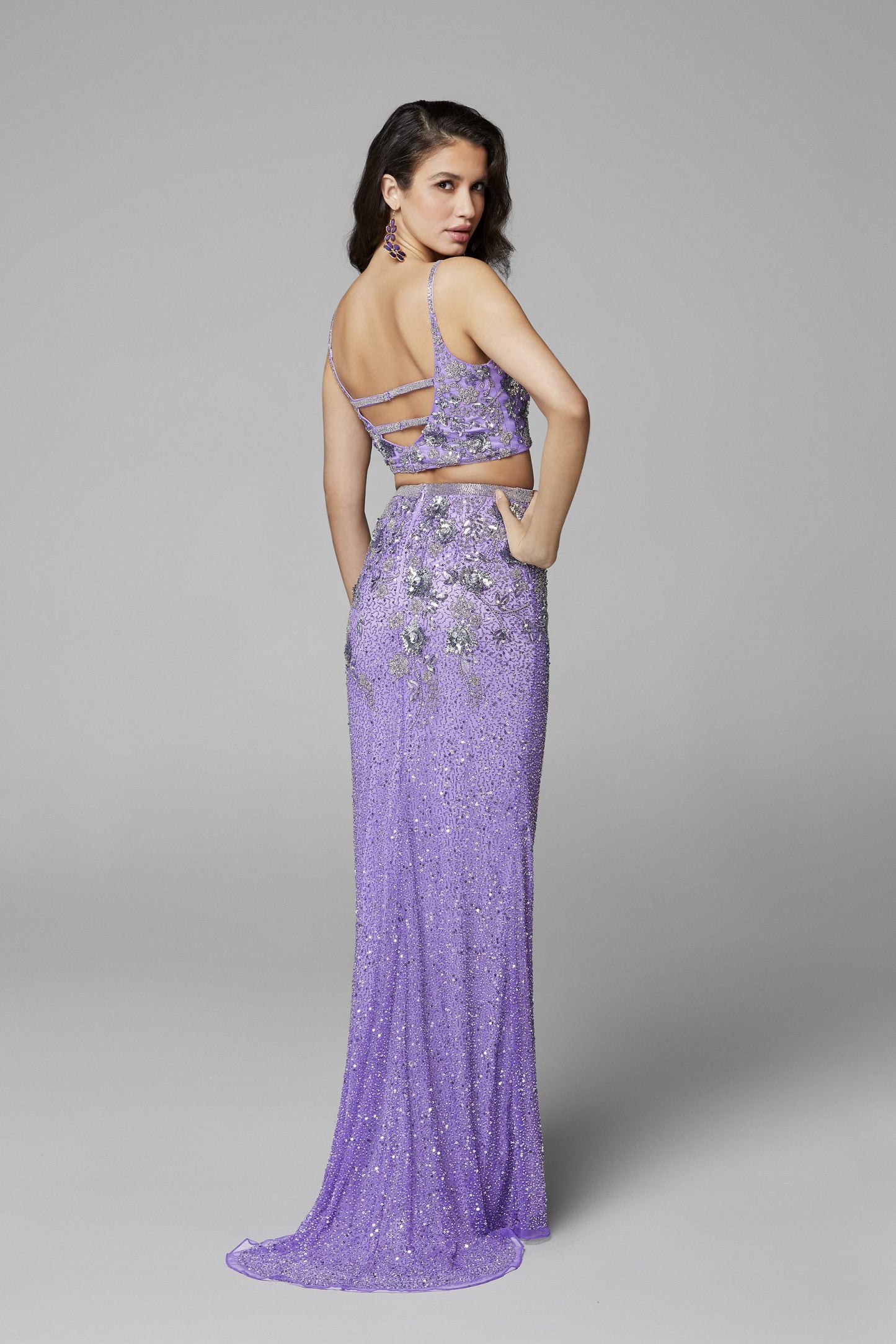 Primavera Couture 3647 is a long fitted two piece formal evening prom dress. Featuring a fitted v neckline bodice with an open back, The skirt has Liquid beaded waist line and a slit & sweeping train. Fully Embellished with beading & Sequins. Detailed Floral patterns are formed and scattered throughout the Pageant gown.   Available Sizes: 00,0,2,4,6,8,10,12,14,16,18  Available Colors: Black, Lilac, Raspberry