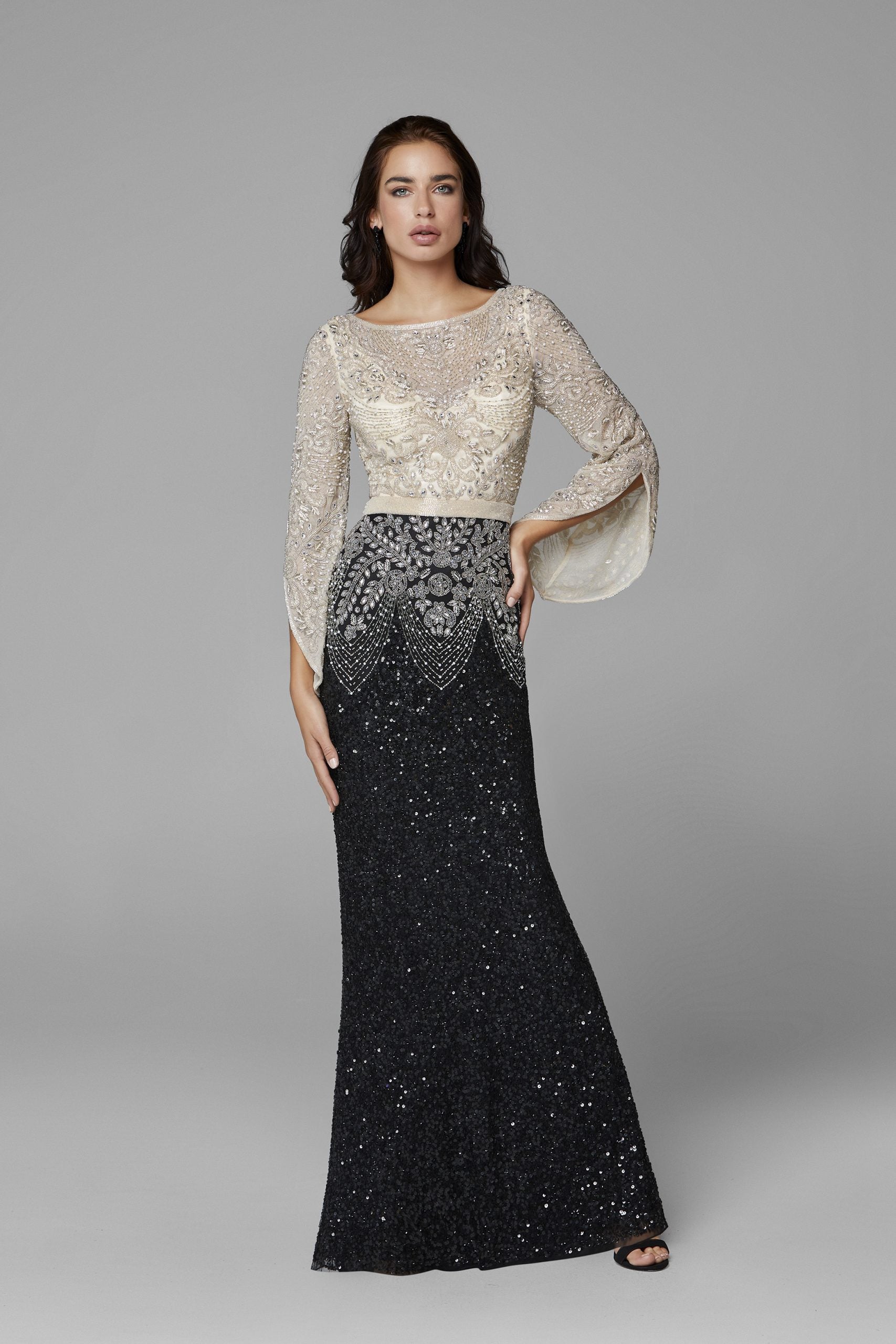 Primavera Couture 3680 This is a long hand beaded evening gown with a bateau neckline and sheer long embellished bell sleeves. It is multi colored and fitted to the floor with an embellished waistline. Available colors:  Black Nude, Charcoal Gold, Forest Green  Available sizes:  0-24