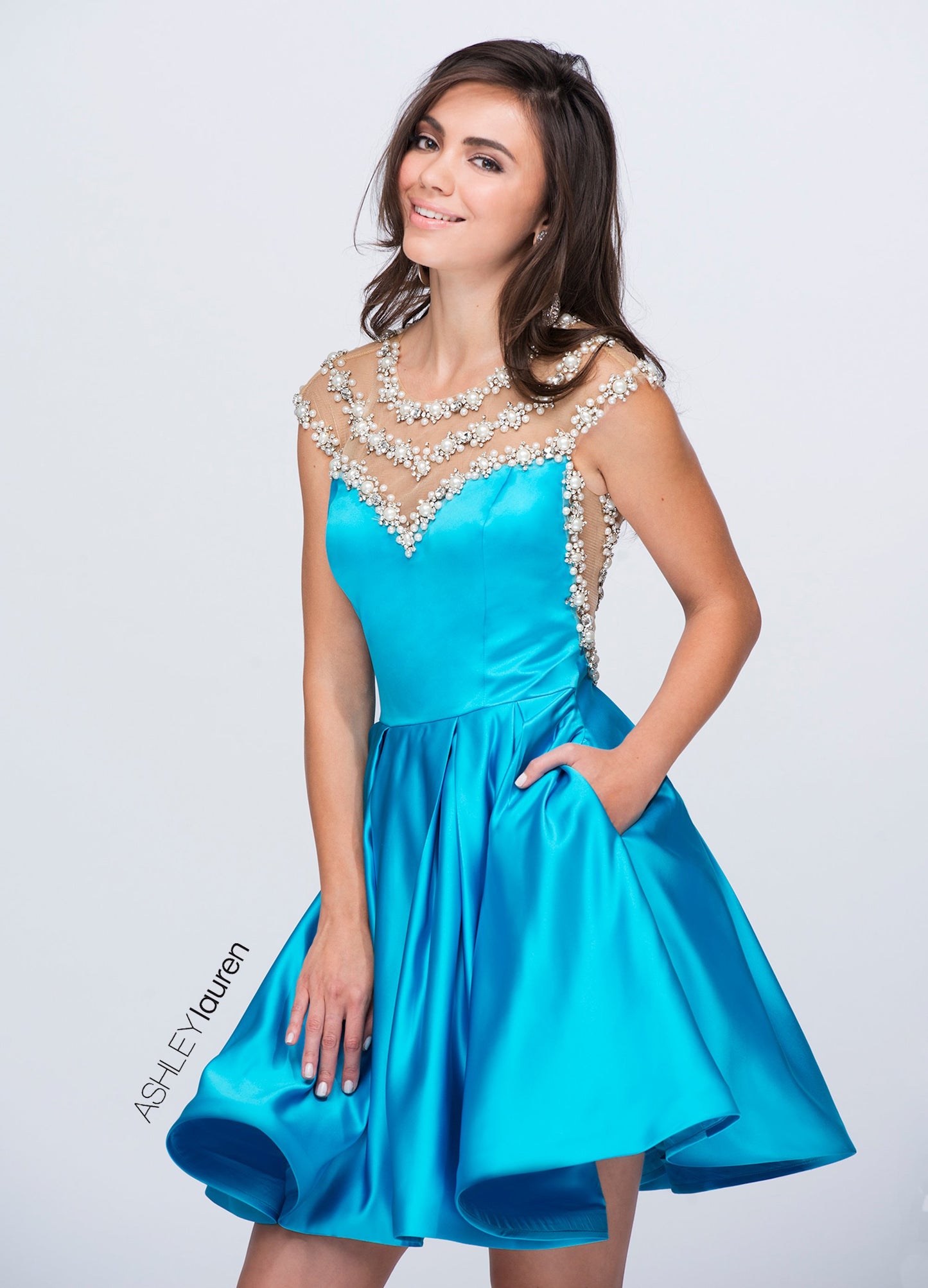 Ashley Lauren 4027 is a Gorgeous Short Fit & Flare Formal Cocktail Dress. Featuring a sheer illusion sweetheart neckline with a fitted satin bodice and sheer side cutouts. This Gown Features rows of Heavily Embellished Crystals, Pearl accents & More! Over the top Glam Style is great for Pageants, Prom & More!  Available Sizes: 4  Available Colors: Turquoise, Black, Fuchsia, Ivory Glass Slipper Formals Lake City Florida