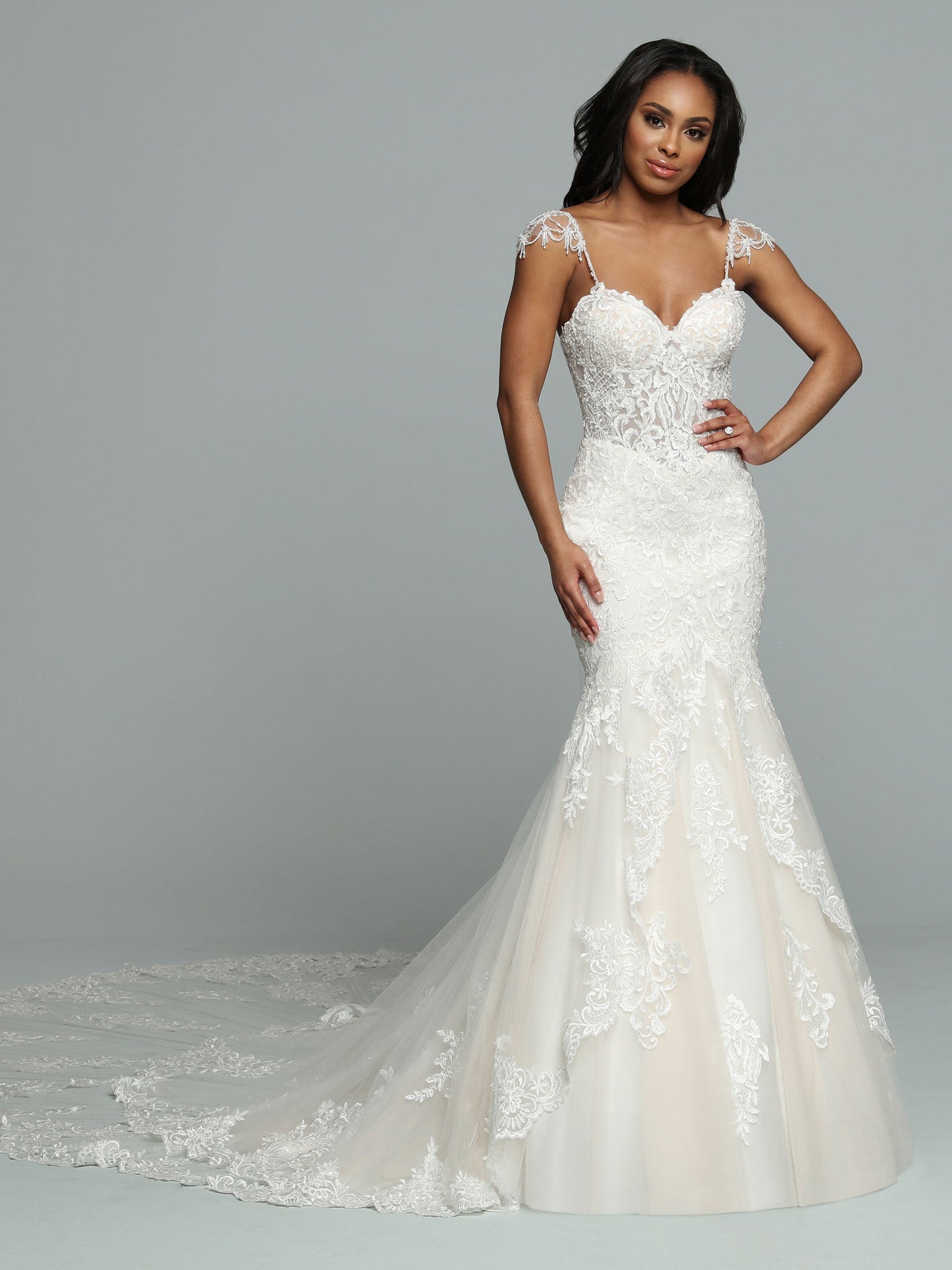 Davinci Bridal 50662 is a stunning long lace formal wedding dress. mermaid silhouette with a sheer lace corset bodice and crystal cap sleeves. Long double layered train with lace embellishments.  Available Size: 14  Available Color: Ivory/Ivory