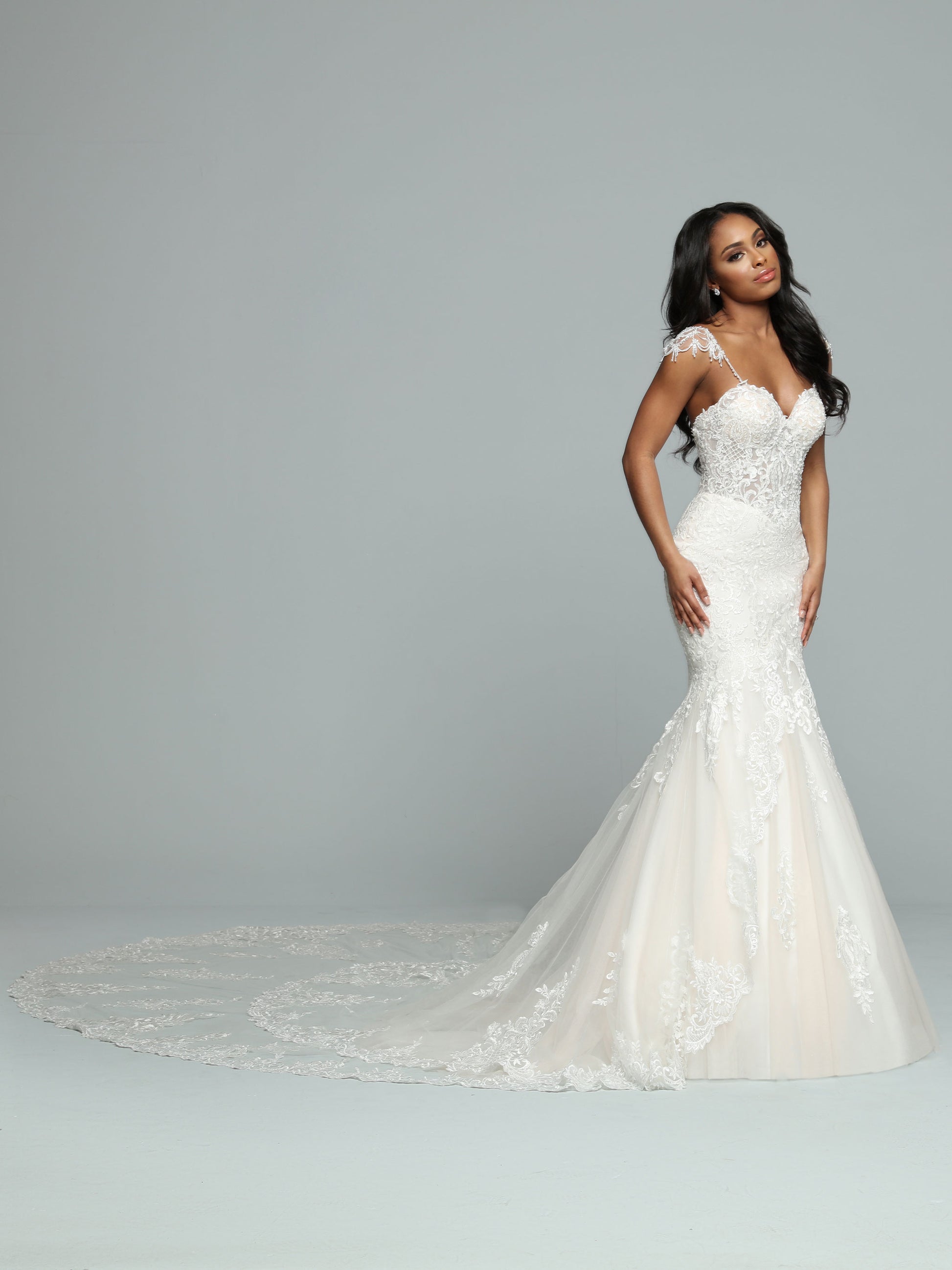 Davinci Bridal 50662 is a stunning long lace formal wedding dress. mermaid silhouette with a sheer lace corset bodice and crystal cap sleeves. Long double layered train with lace embellishments.  Available Size: 14  Available Color: Ivory/Ivory