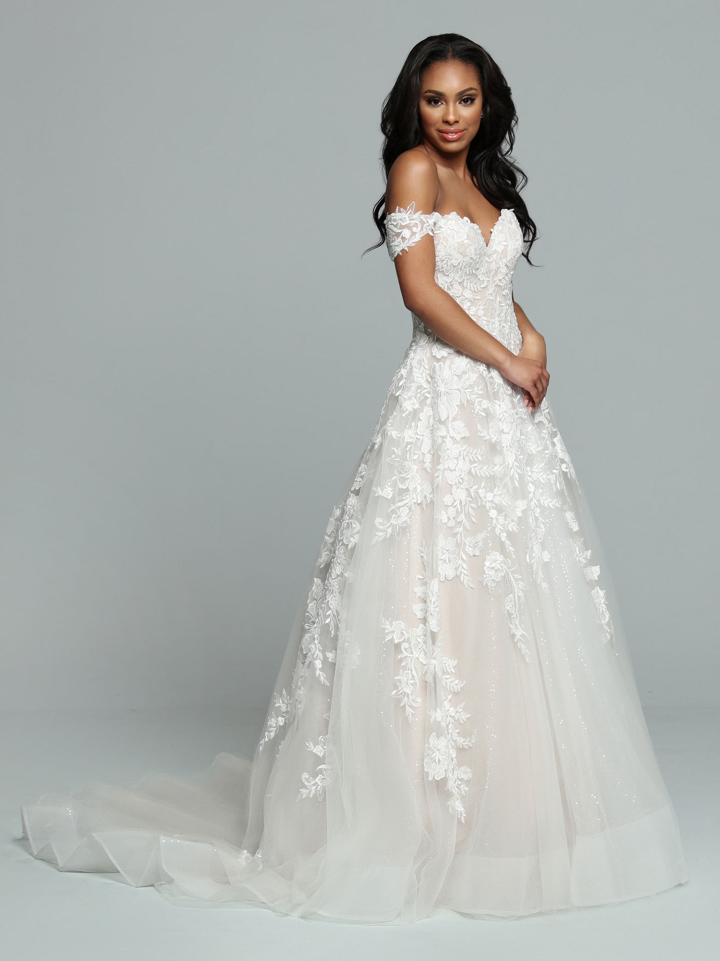 Davinci Bridal 50668 is an A Line formal wedding dress. Featuring a fitted bodice with off the shoulder sheer removable straps and sweetheart neckline. Floral lace embellishments over a sequin shimmer ballgown skirt with train. Lace up corset back.   Available Sizes: 2-20  Available Colors: Ivory/Ivory, Ivory/Latte, White/White