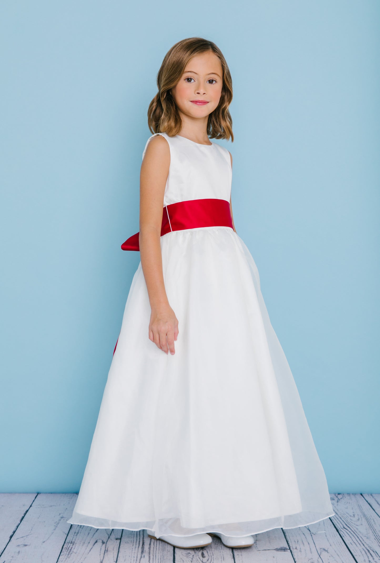 Rosebud Fashions Style 5101 is a sleeveless full length dress with a scoop neckline. Natural waist is accented with a satin sash with self-tying streamers. Satin buttons cover the zipper.  Long High Neck Flower Girl Dress Sash Buttons First Communion.  Available Sizes: 2, 4, 6, 8, 10, 12, 14, 16  Available Colors: White, Ivory