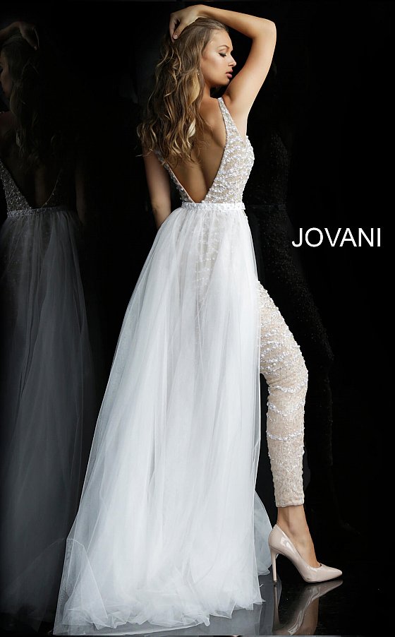 Jovani 60010 embellished v neckline jumpsuit with removable tulle overskirt  Available colors:  Nude/White, Nude/Black  Available sizes:  00-24   Details: Nude and white beaded prom jumpsuit with low v-neckline, sleeveless fitted bodice and low v-back, full length slim leg pants and detachable sheer tulle full length over-skirt.  