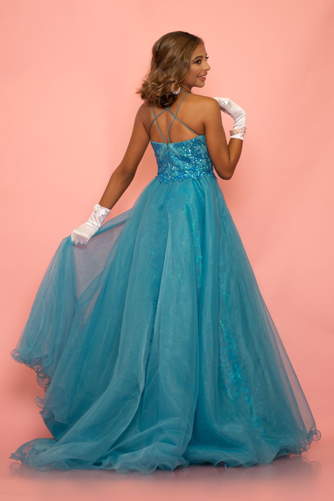 Sugar Kayne C112  by Johnathan Kayne is a stunning girls long pageant gown featuring a lush organza overskirt. This high modest halter neckline is great for kids & preteens! A Line / Fitted Stretch  silhouette is Embellished with a gorgeous sequin scrolling design.   Available Colors: Magenta, Teal  Available Size: 2-16