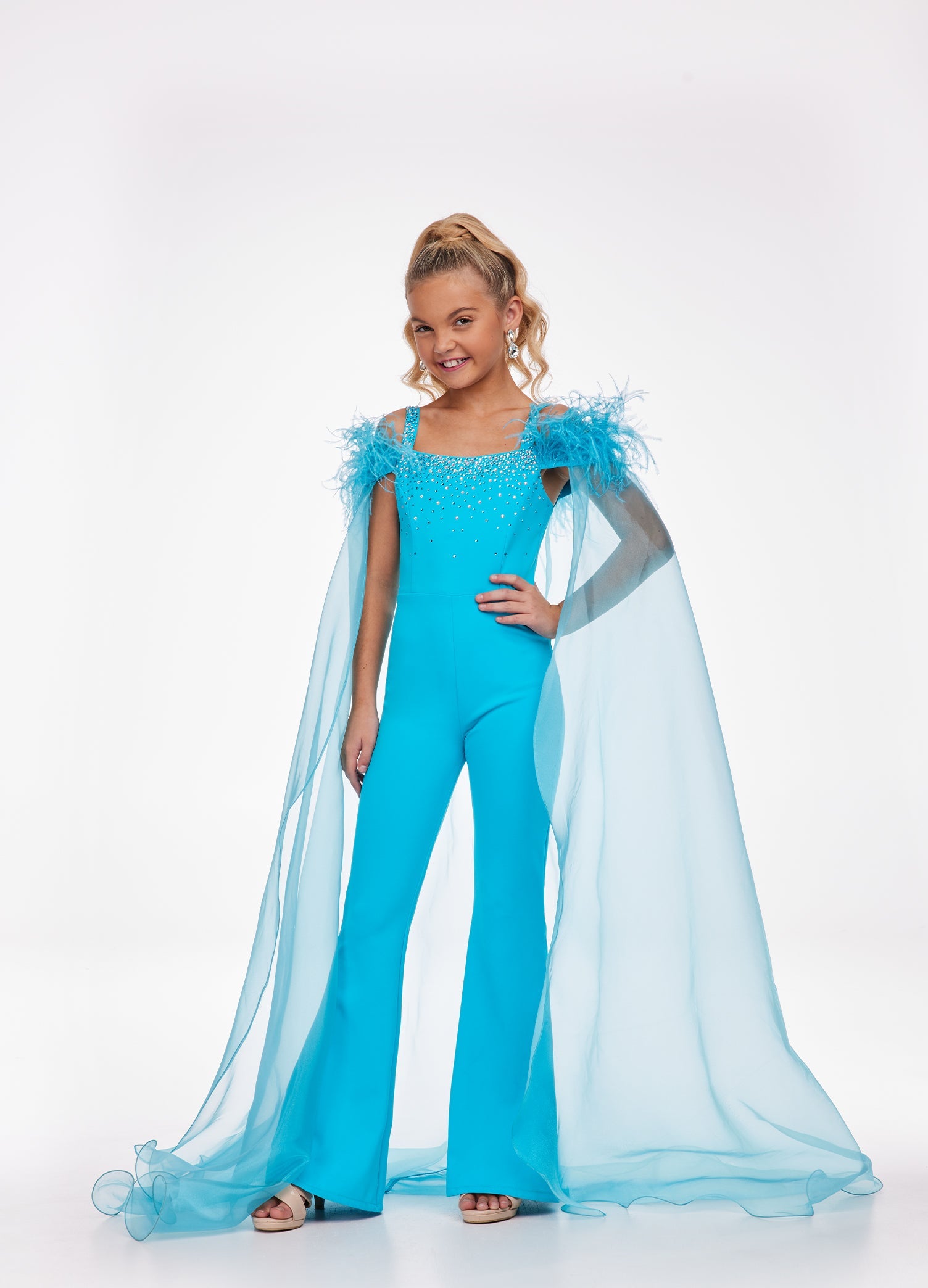 Ashley Lauren Kids 8100 Embellished Pageant Jumpsuit Feathers Cape Girls Fun Fashion Bring the drama in this scuba jumpsuit featuring heat set stone straps giving way to scattered stoning throughout the bustier. The jumpsuit is accented with off the shoulder feather details and an organza cape. Scuba Jumpsuit Press On Details Organza Cape Feathers Available Sizes: 2-16 Available Colors: Turquoise, Hot Pink