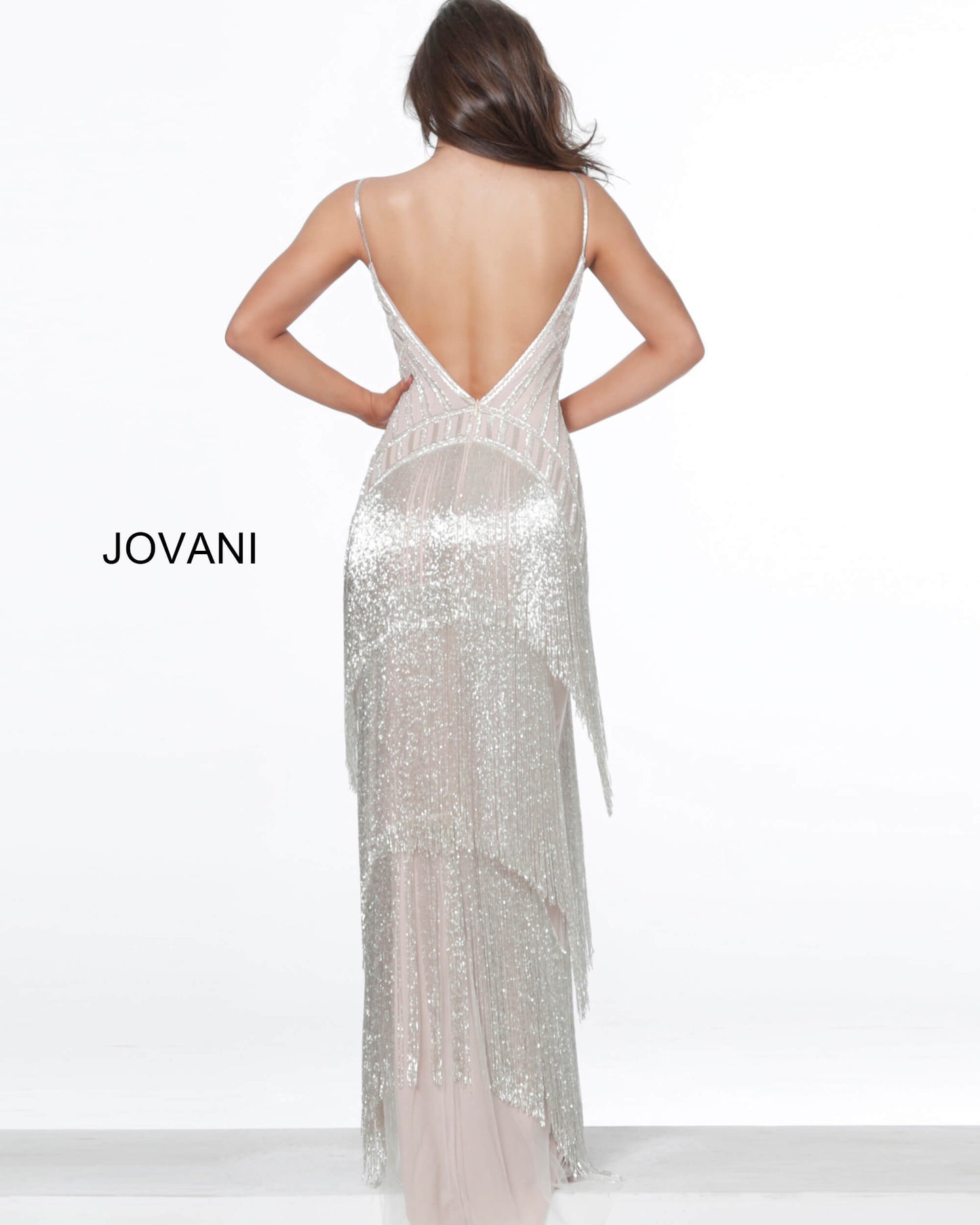 Jovani 8101 This evening gown is a silver nude prom dress features a fitted silhouette with linear sequin beadwork on the bodice and tiered fringe trim along the long skirt.  Spaghetti straps support the mesh insert plunging neckline and the open V-back. Make a statement at your next pageant or special event.  Color  Silver/Nude  Sizes  00, 0, 2, 4, 6, 8, 10, 12, 14, 16, 18, 20, 22, 24 