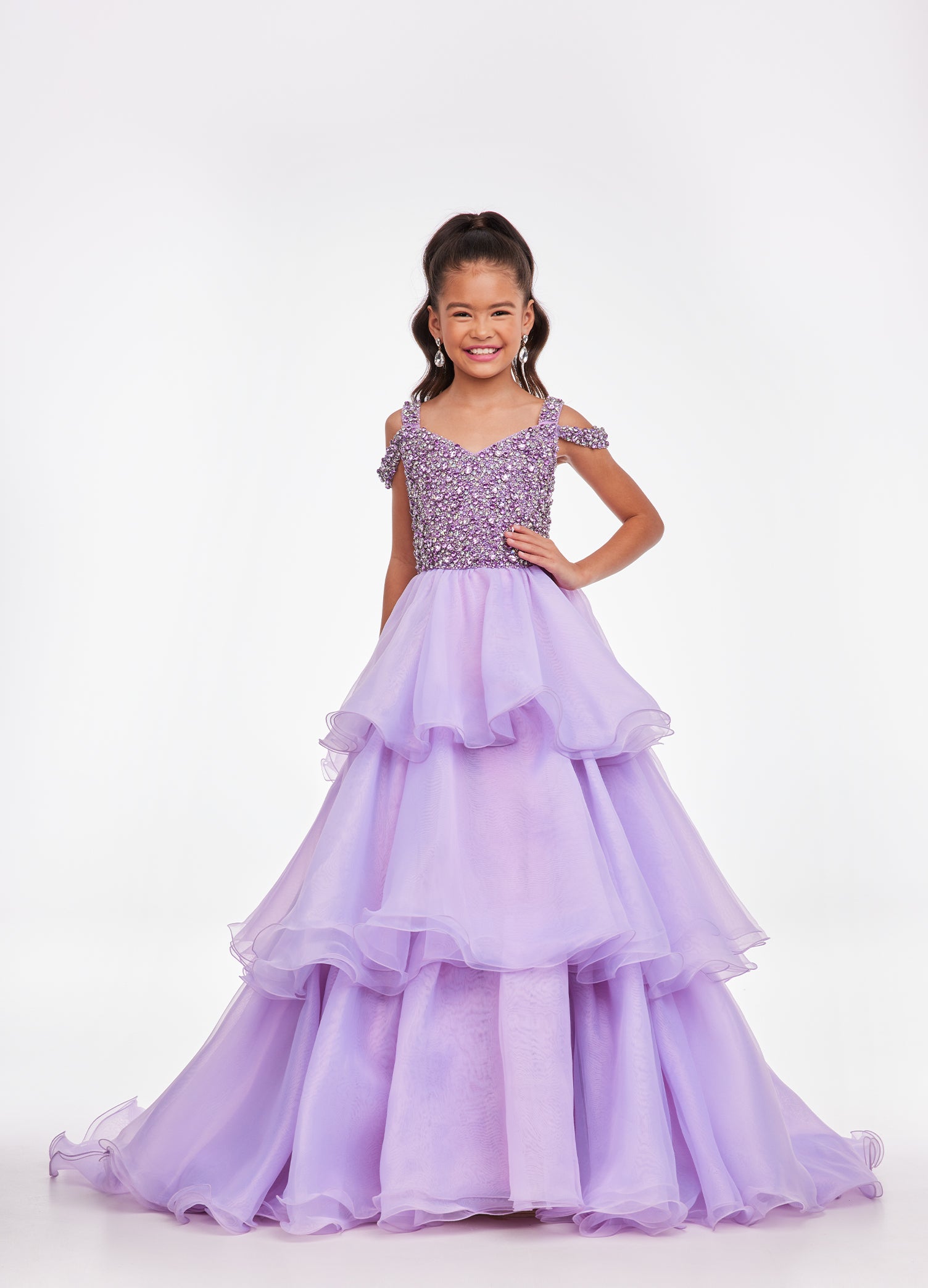 Ashley Lauren Kids 8101 Girls Pageant Dress.  The crystal encrusted bodice on this kids Pageant Gown consists of a slight V-Neckline and off the shoulder straps. The A Line multi-tiered organza ruffle skirt completes the look with a long train.   Available colors:  Hot Pink, Lilac, Turquoise