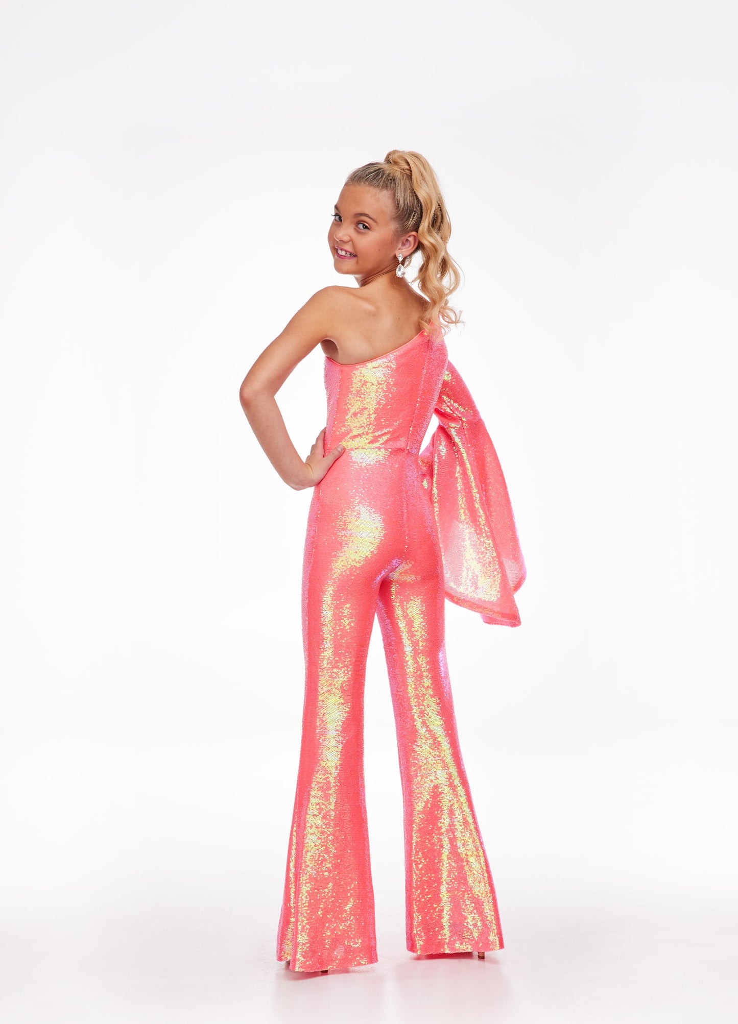 Ashley Lauren Kids 8110 One Shoulder Jumpsuit Long Bell Sleeve Sequin Pageant This groovy one shoulder jumpsuit features an oversized bell sleeve and flared pants. One Sleeve Oversized Bell Sleeve Sequin Fabric Jumpsuit Available Sizes: 2-16 Available Colors: Coral, Lilac, Yellow, Neon Green