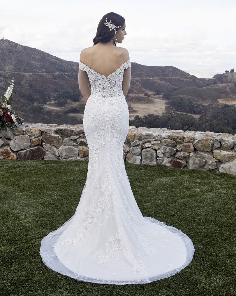 Casablanca Bridal 2419 MCKENZIE Wedding Dress Overskirt Bridal Gown off the shoulder  Beach wedding dress glam rises to a whole new level of beauty with Style 2419 McKenzie by Casablanca Bridal. Beaded lace appliques take shape as subtle stars and flowing botanicals, sitting delicately atop sequined tulle that catches the sunlight at every angle. A classic fit-and-flare silhouette hugs the natural shape of the body comfortably, while a removable organza skirt attachment with matching lace appliques, 