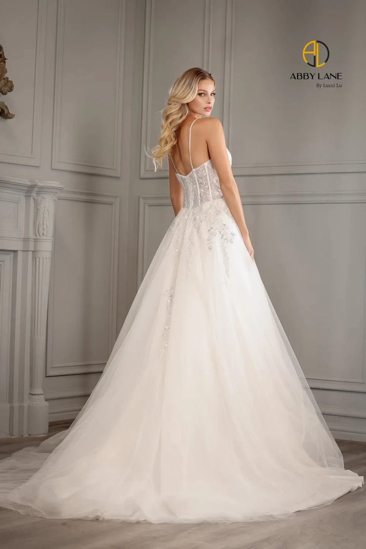 Abby Lane Bridal 97177 is a beautiful Long A Line lace tulle Ballgown featuring a v-neckline, sheer back and a beaded bodice with a sequined embellishment. The waist is accented with a satin belt and features a long train. This stunning gown is perfect for a bridal ceremony.  Sizes: 2-14   Color: Ivory/Champagne