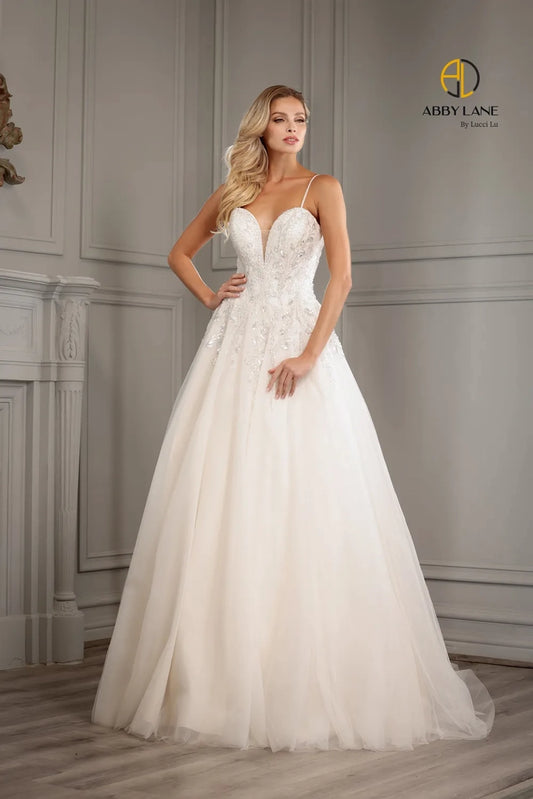 Abby Lane Bridal 97177 is a beautiful Long A Line lace tulle Ballgown featuring a v-neckline, sheer back and a beaded bodice with a sequined embellishment. The waist is accented with a satin belt and features a long train. This stunning gown is perfect for a bridal ceremony.  Sizes: 2-14   Color: Ivory/Champagne
