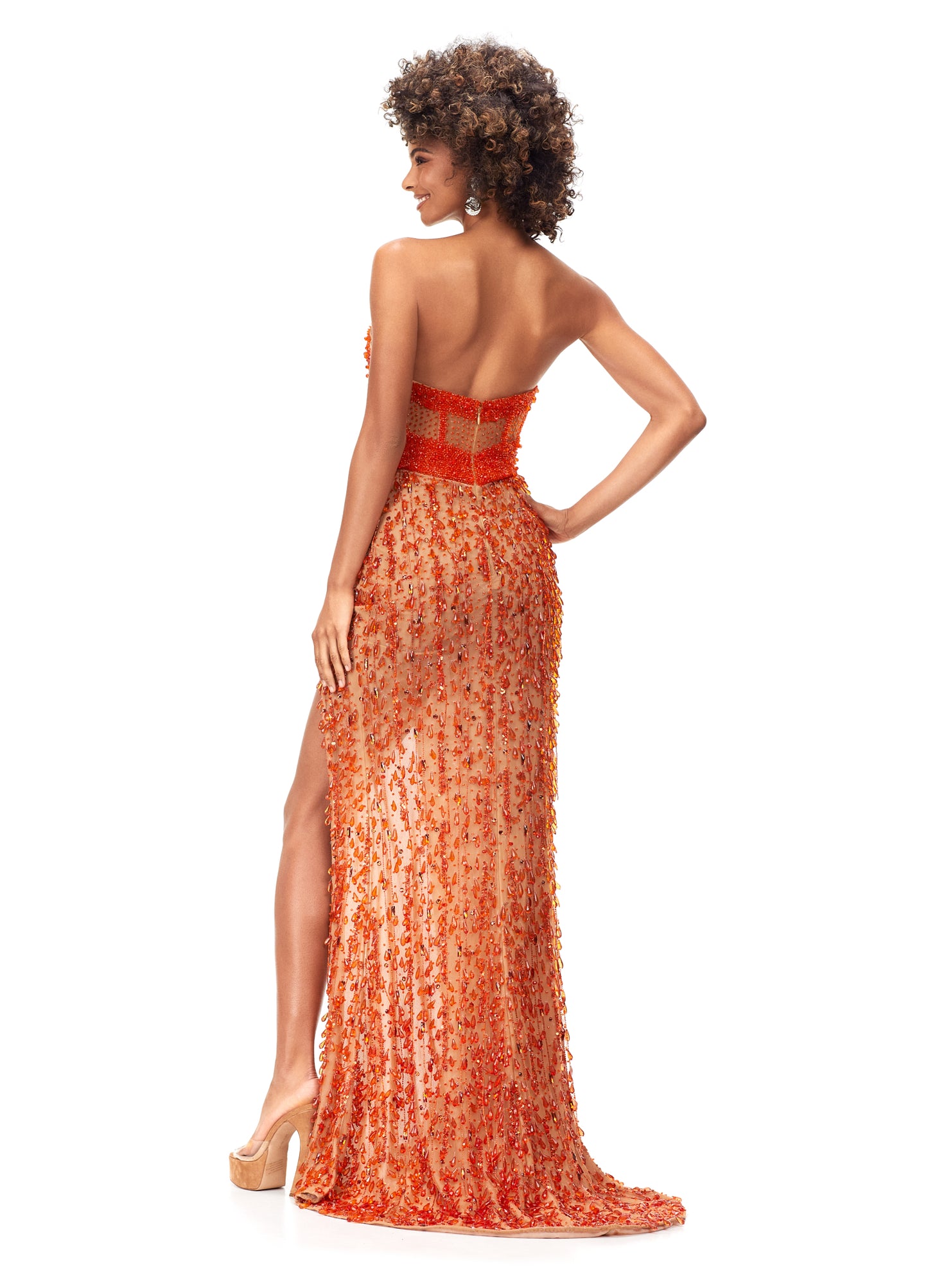 Ashley Lauren 11275 This stunning strapless evening gown features an illusion corset bustier embellished with beading. The fitted skirt is complete with fringe and a left leg slit. Sweetheart Neckline Illusion Corset Bustier Left Leg Slit Fringe COLOR: Orange