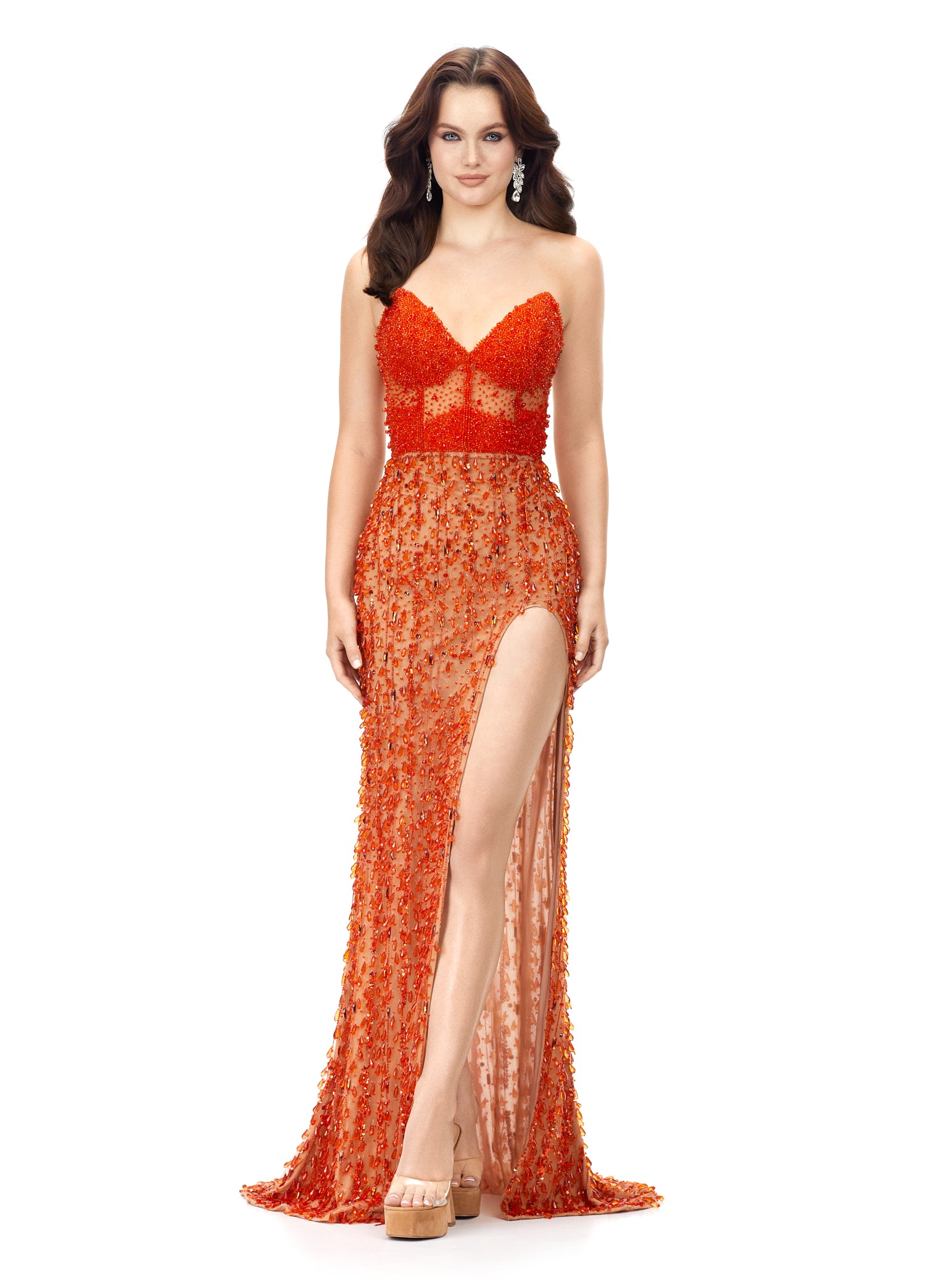 Ashley Lauren 11275 This stunning strapless evening gown features an illusion corset bustier embellished with beading. The fitted skirt is complete with fringe and a left leg slit. Sweetheart Neckline Illusion Corset Bustier Left Leg Slit Fringe COLOR: Orange