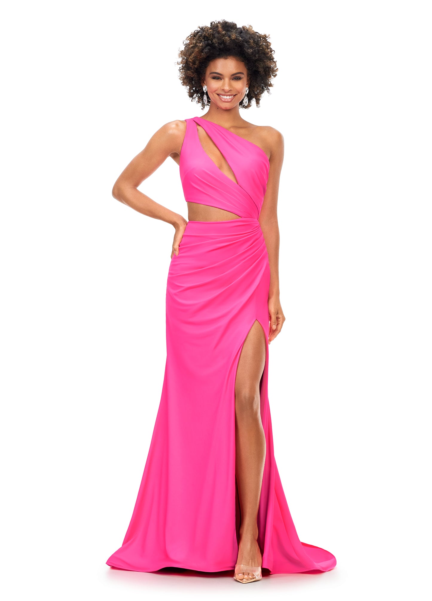 Ashley Lauren 11303 This one shoulder jersey gown features a ruched bodice with asymmetrical cut outs. The ruching continues onto the fitted skirt with slit. The look is complete with an exposed metal zipper back.