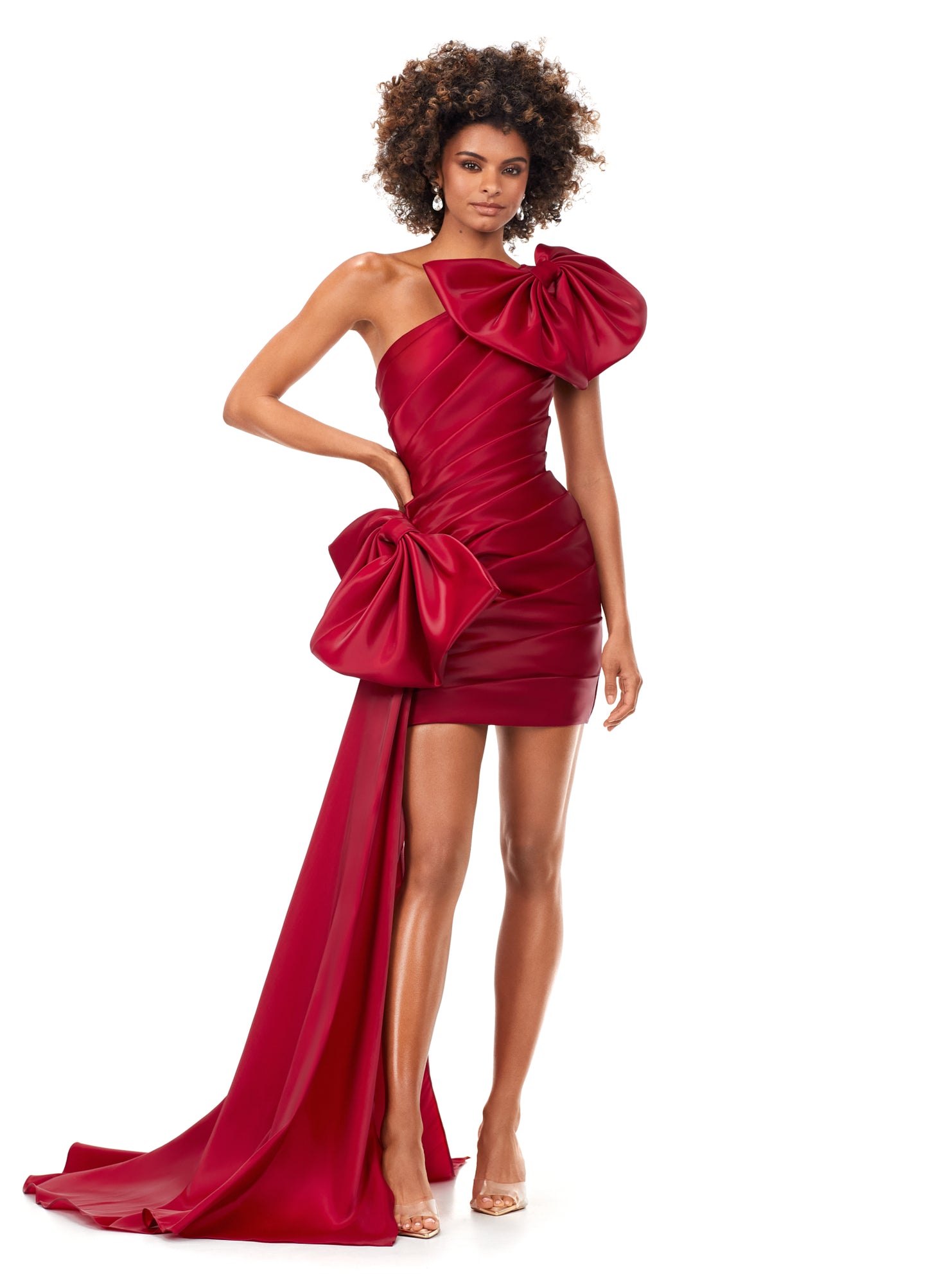 Red Ashley Lauren 11327 This ultra chic one shoulder cocktail dress is complete with bows. The ruched bodice and fitted skirt provide the perfect silhouette. The hip is accented with an oversized bow and side skirt.