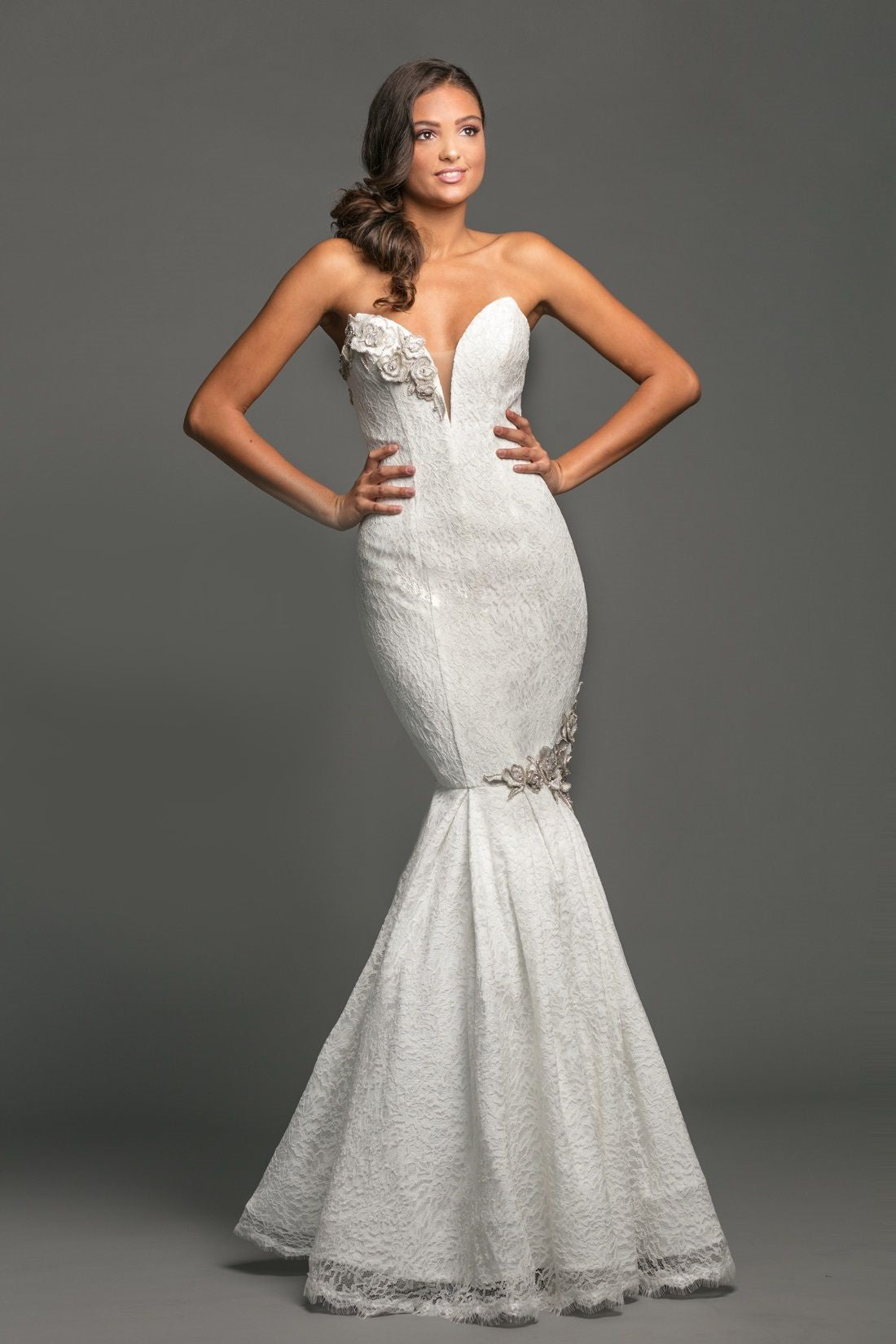 Johnathan Kayne Bridal B111 is a stunning Lace Mermaid Bridal Gown Featuring subtle pops of metallic silver in the lace to match the detailed crystal 3D floral appliques across the top & along the trumpet skirt. Lace up corset back. This would also make a stunning Prom or Pageant Dress!  Available Size: 6, 14  Available Color: Ivory