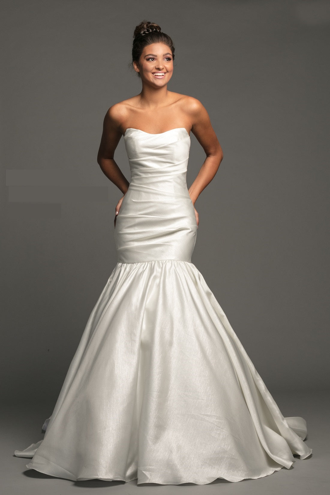Johnathan Kayne B118 is a stunning Long Mermaid Wedding Dress in Diamond White. This long shimmering Pleated gown features a gathered bodice for a flattering silhouette. Fit & Flare With a stunningly lush Trumpet skirt with a sweeping train. Material features a shimmering Glow. Great Plus Size Formal Gown.  Available Color: Diamond White  Available Size: 20