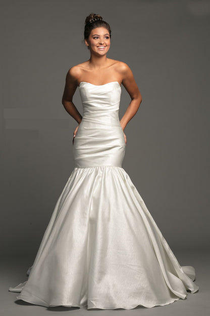 Johnathan Kayne B118 is a stunning Long Mermaid Wedding Dress in Diamond White. This long shimmering Pleated gown features a gathered bodice for a flattering silhouette. Fit & Flare With a stunningly lush Trumpet skirt with a sweeping train. Material features a shimmering Glow. Great Plus Size Formal Gown.  Available Color: Diamond White  Available Size: 20