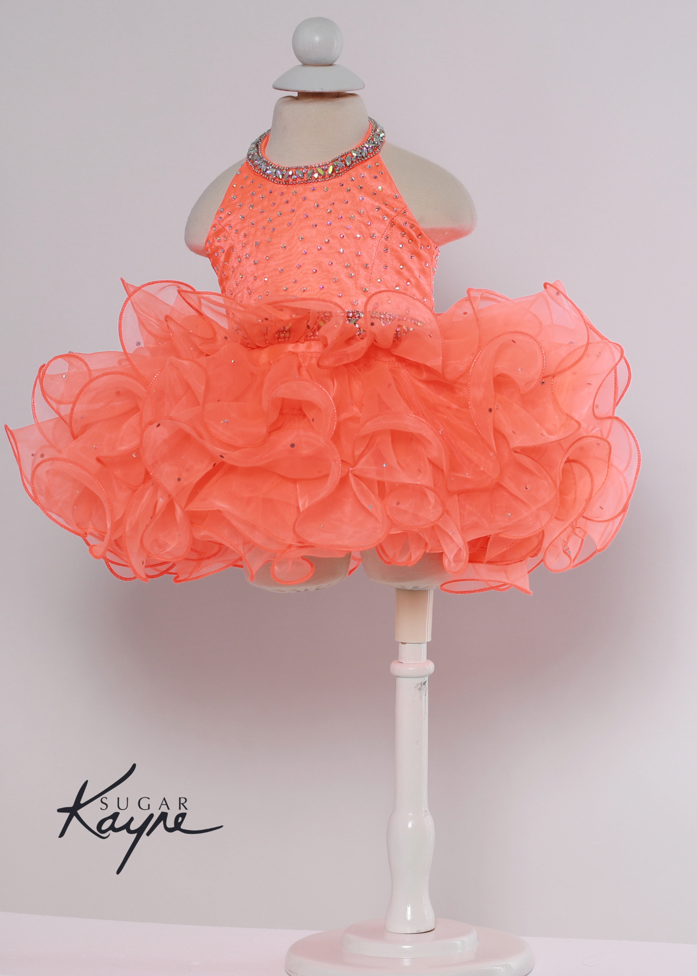 Sugar Kayne C220 Girls Baby Halter Cupcake Ruffle Pageant Dress Corset Formal Gown Have your little cupcake bring on all the charm in this stunning organza gown. The corset back is the perfect addition as the little one grows!  Colors: Bubblegum, Neon Orange, White  Sizes: 0M, 12M, 18M, 24M, 2T, 3T, 4T, 5T, 6M, 6T  Fabric Organza, Satin Lining
