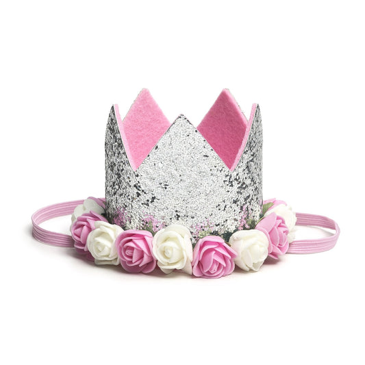 Sweet Wink - The Silver Flower Crown is the perfect addition to any birthday party or everyday dress up! Since this crown does not have a number on it, it can be worn for multiple occasions. Makes a great birthday present for any little girl in your life! Item description:  Silver glitter crown Pink and ivory flowers trim the base of the crown Light pink felt lining inside the crown and on the bottom of the crown to ensure comfort and softness on the child's head Light pink elastic to secure crown to child'