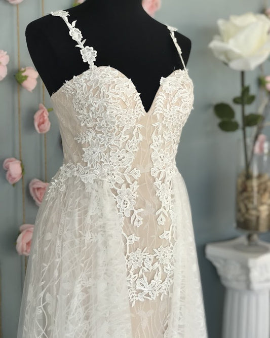 Nina Cancci 3159 is a long Lace Fitted Ivory Floral Lace Applique strap wedding dress. cracked Ice Over skirt and sweeping train. Stunning Destination Bridal Gown. Great for Plus Size! Glitter sweetheart neckline. Accented scroll pattern on the flowing overskirt. shimmering bridal gown or unique wedding dress. Sheer lace embellished straps.   Available Sizes: 8  Available Colors: Ivory/Nude