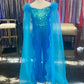 Marc Defang 8099K is a KIDS long pageant formal wear jumpsuit that is made of sequins and has off the shoulder straps.  The straps are attached to a cape with feathers at the shoulders.  Wow the crowd at your next pageant.  Available colors:  Blue  Available sizes:  6