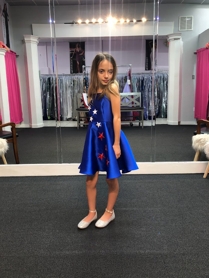 Marc Defang 5030 Red White & Blue Girls Pageant Fun Fashion Cape Detachable chiffon skirt/cape. Stars adorn he short a line dress. Perfect for Fun Fashion!  Available Sizes: 4-14  Colors: Red/White/Blue