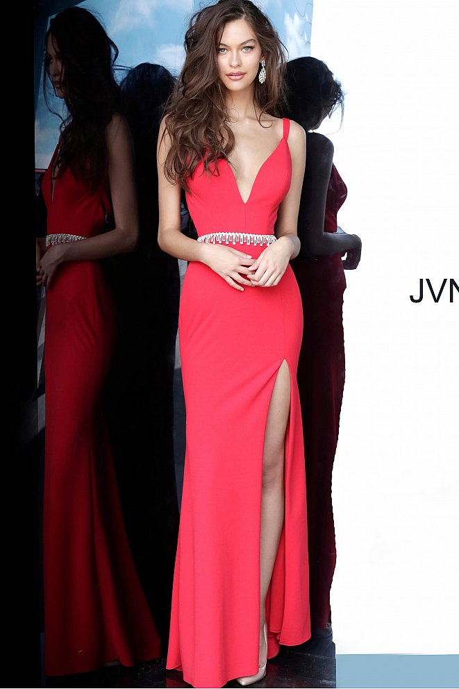 JVN by Jovani 02712 is a long Fitted Low Cut V neck Prom, Pageant & Formal evening wear dress. Long Fitted gown with an embellished tassel crystal waist belt. Open criss cross back.  Stunning classic gown. fitted bodice with slightly flared skirt featuring a slit.