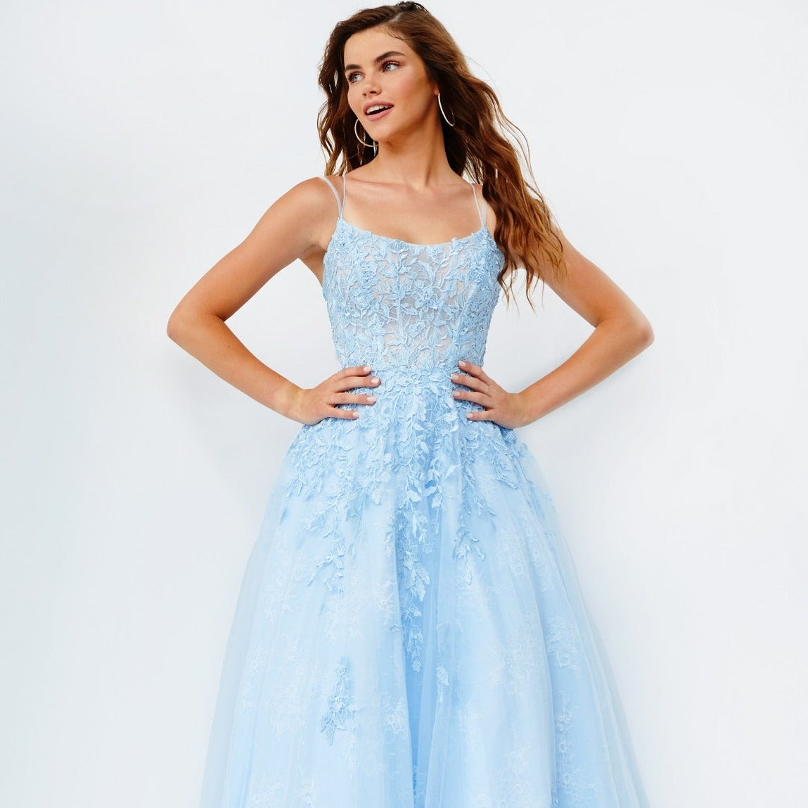 Jovani JVN06644 is a Long Lush Ballgown Prom Dress. This gown features a sheer fitted bodice with a scoop neckline and spaghetti straps. Floral lace appliques Embellish the top and cascade down into the full a line skirt. Open corset lace up tie back with a sweeping train