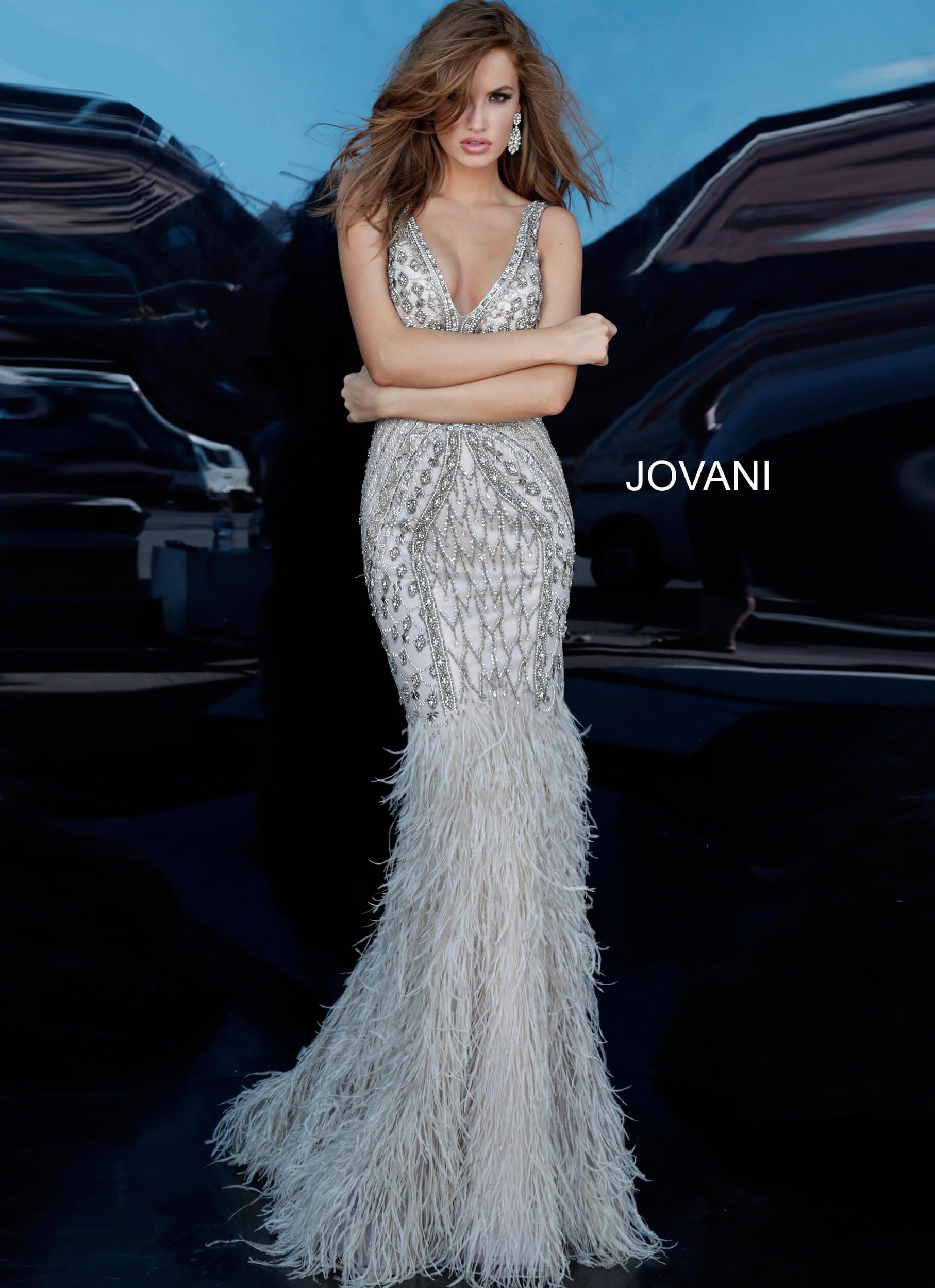 Jovani 02798 beaded v neckline fitted evening gown with mermaid feather skirt prom dress pageant gown Silver and multicolor beaded evening dress with a sleeveless fitted sheer bodice, v-neckline and low v-shaped back with hidden zipper. Floor-length form-fitting skirt with a feather trim mermaid shape end. Available colors:  Silver  Available sizes:  00-24 