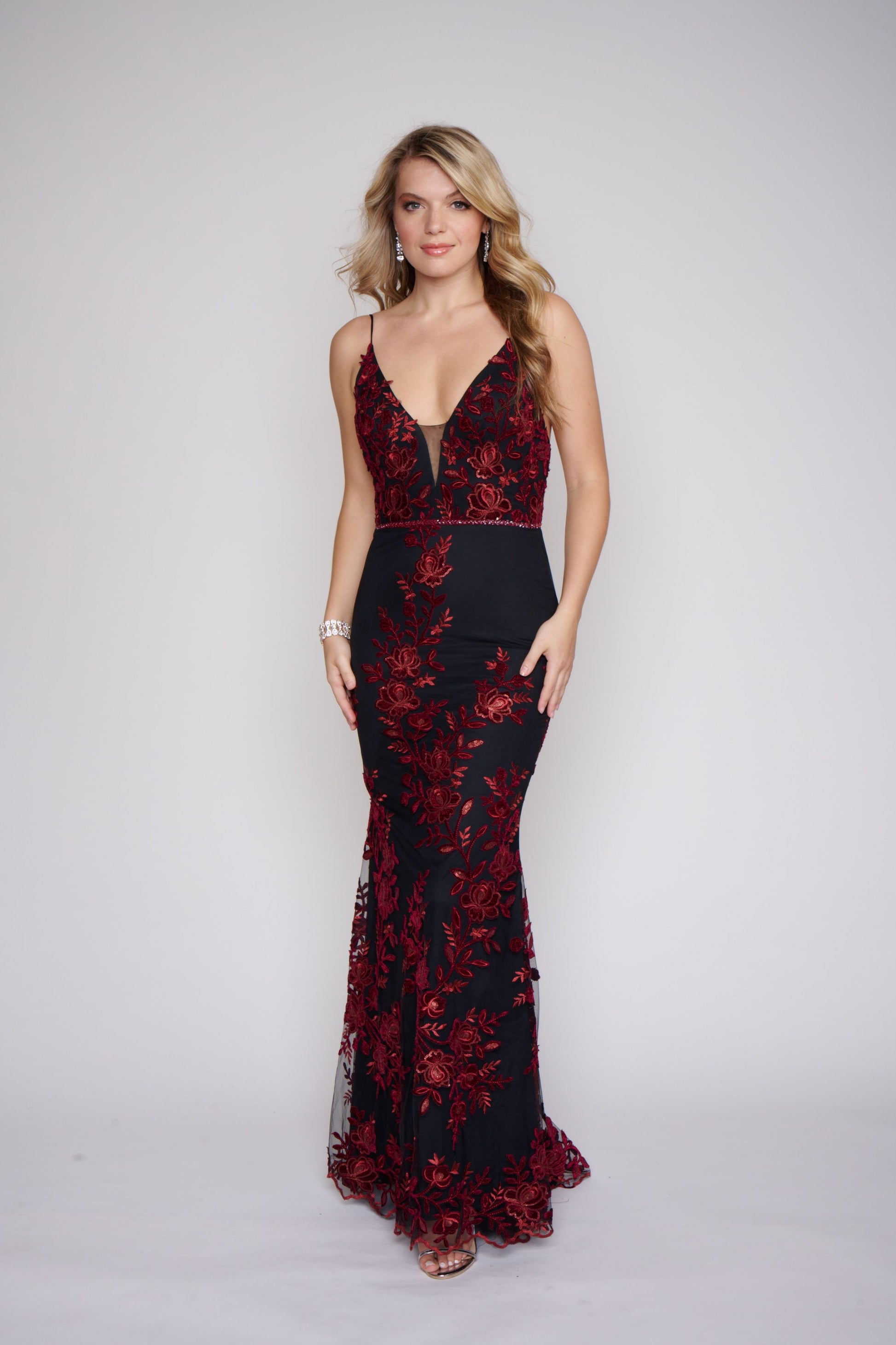 Nina Canacci 2240 Black Burgundy Long Prom Dress Fitted Evening Gown Floral Lace Dress This dress has a v neckline with sheer courtesy panel and a sheer lace back.  It is fully appliqued with Burgundy lace.  The fit and flare design is gorgeous on you and it has a matching embellished belt. 